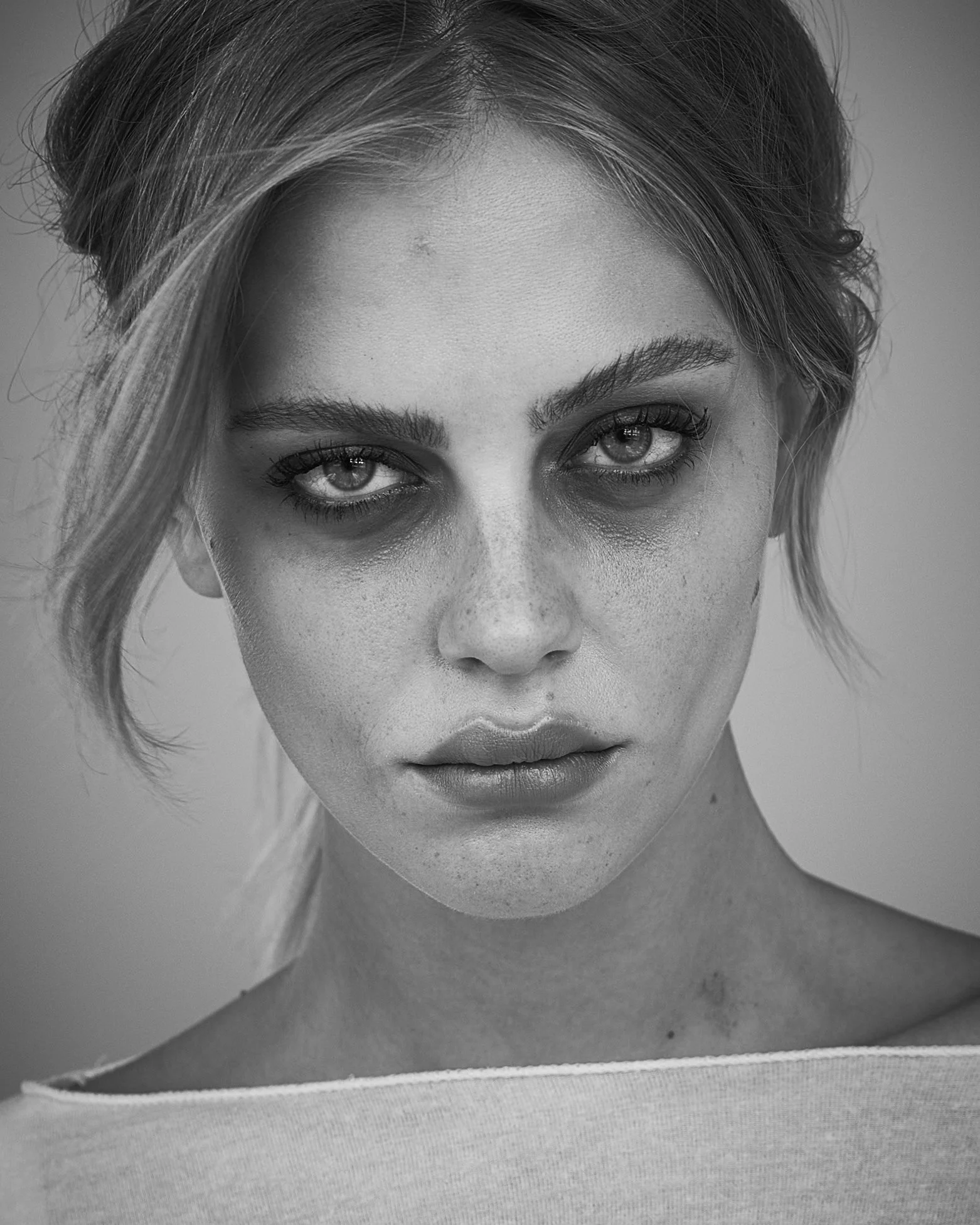 Close-up black and white portrait of a young woman with short hair and intense stare.