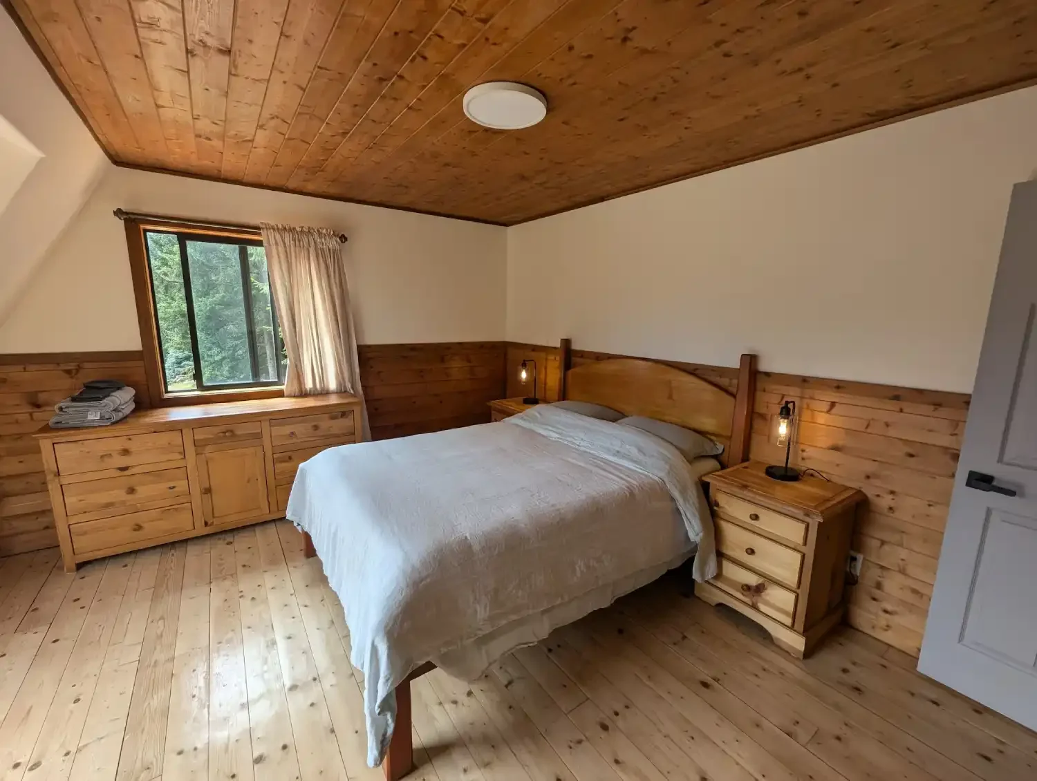 Cozy bedroom with wooden bed frame, floors and furniture