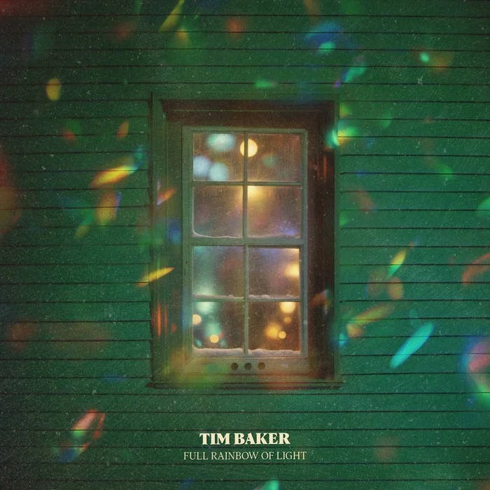 A green wooden house with a window, surrounded by colorful light reflections, with text at the bottom reading "Tim Baker - Full Rainbow of Light."
