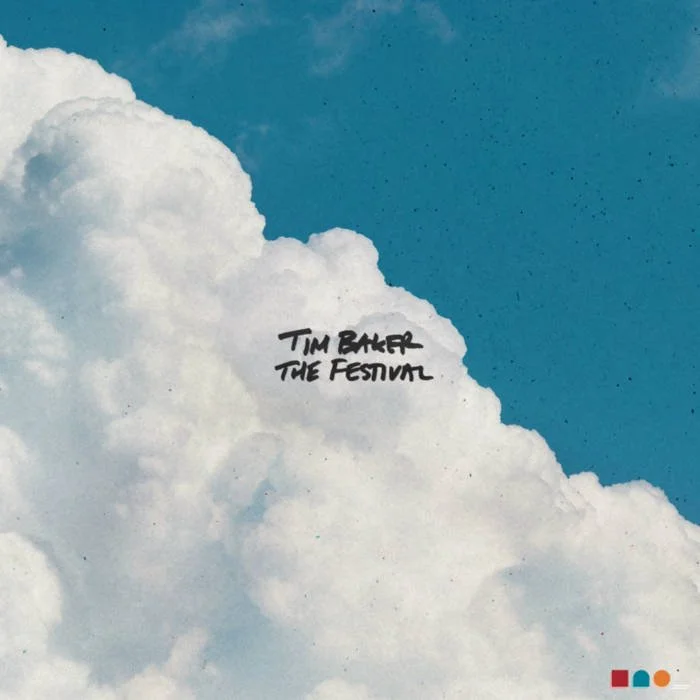 Sky with large fluffy clouds showing the text 'Tim Barker The Festival' handwritten in black