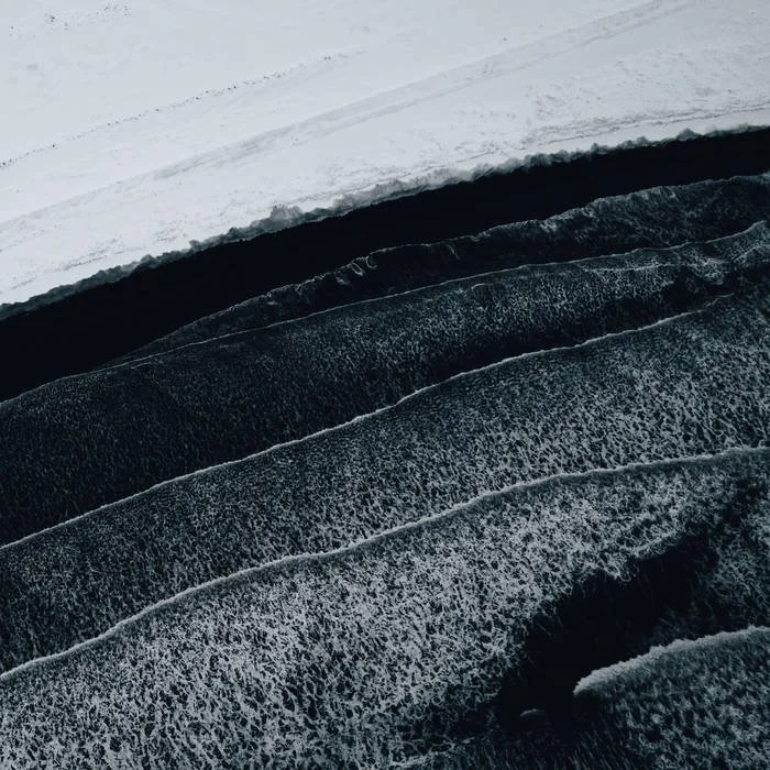 Close-up of layered ice sheets with black and white ice textures.