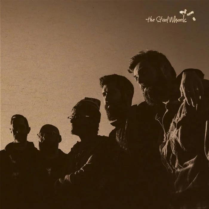 Silhouettes of five men standing closely together against a plain background.