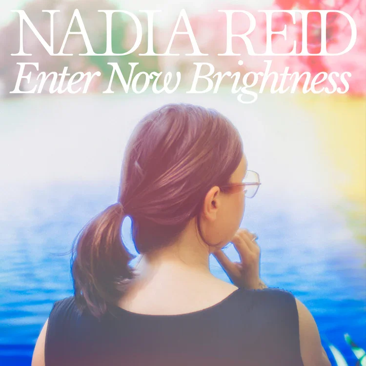 Book cover featuring a woman with brown hair tied in a ponytail and sunglasses, looking at a lake with colorful foliage in the background, titled 'NADIA REID Enter Now Brightness'.