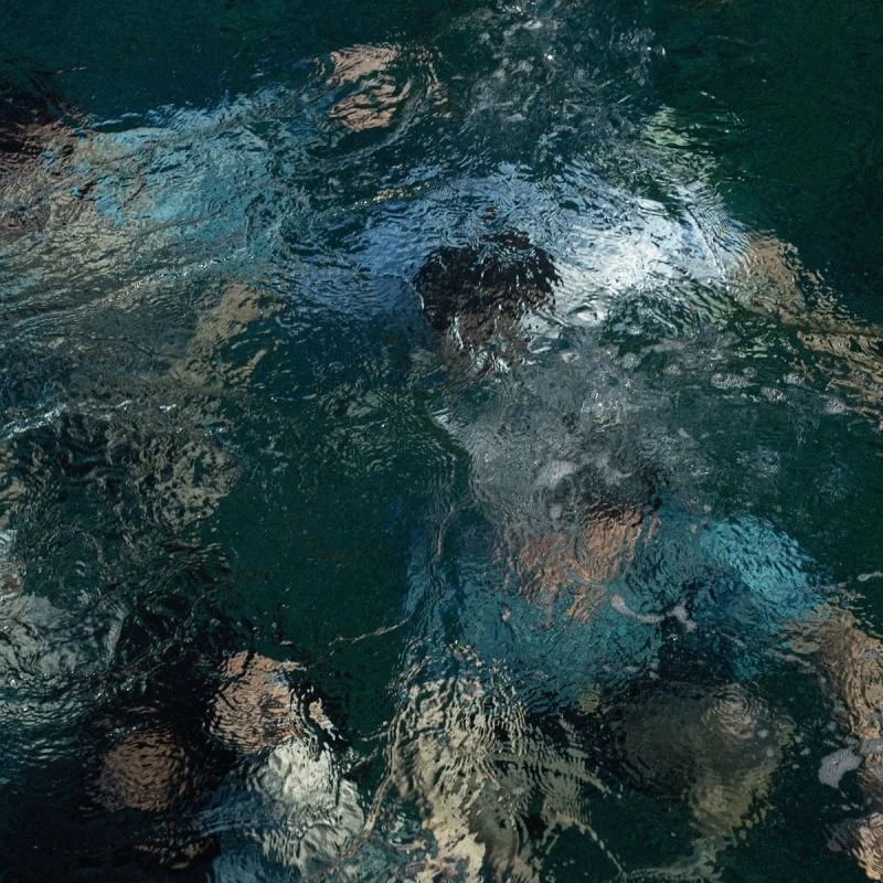 Person swimming underwater in a pool.
