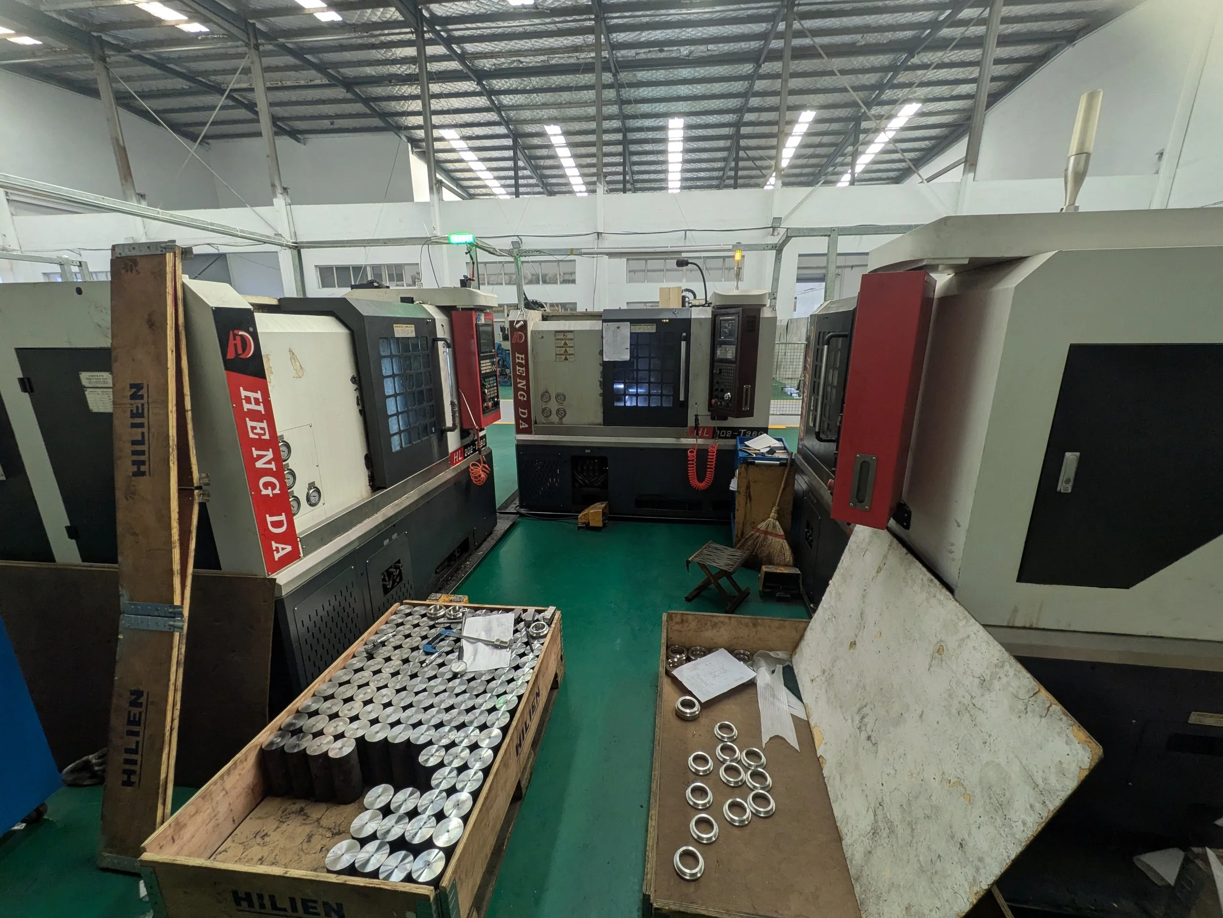 Industrial manufacturing workshop with CNC machines and workbenches containing metal parts and tools.