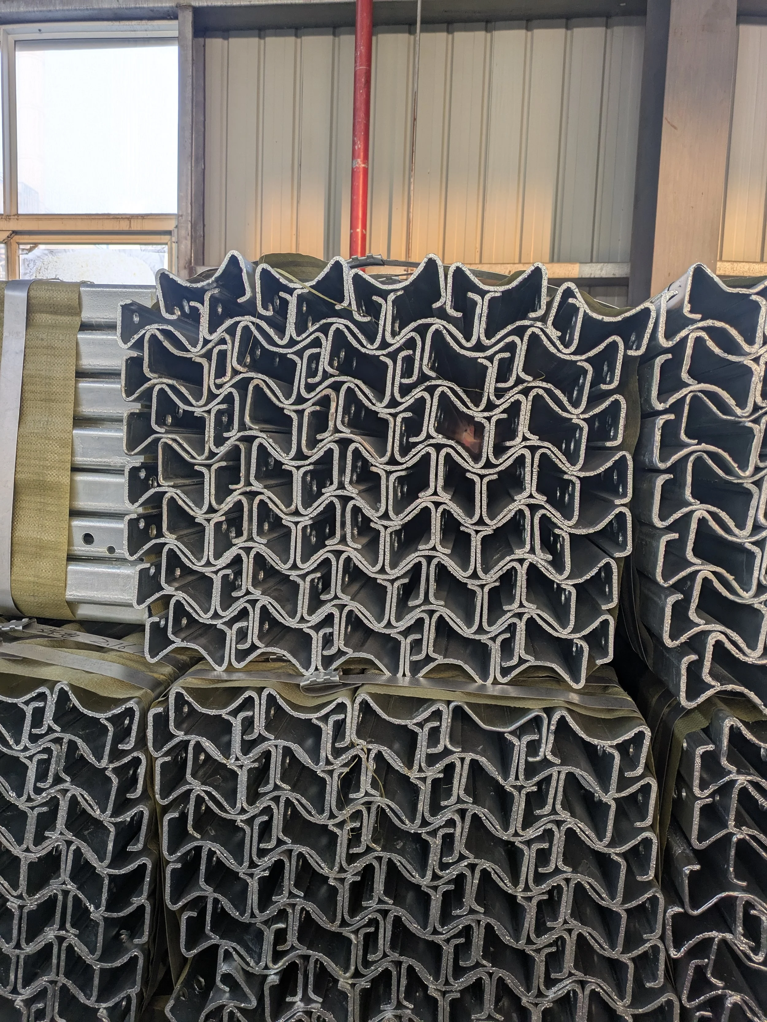 Stacks of metal U-channel beams stored inside a warehouse