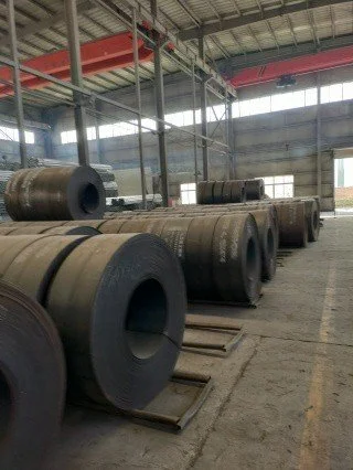 Large metal rolls stored in a warehouse.