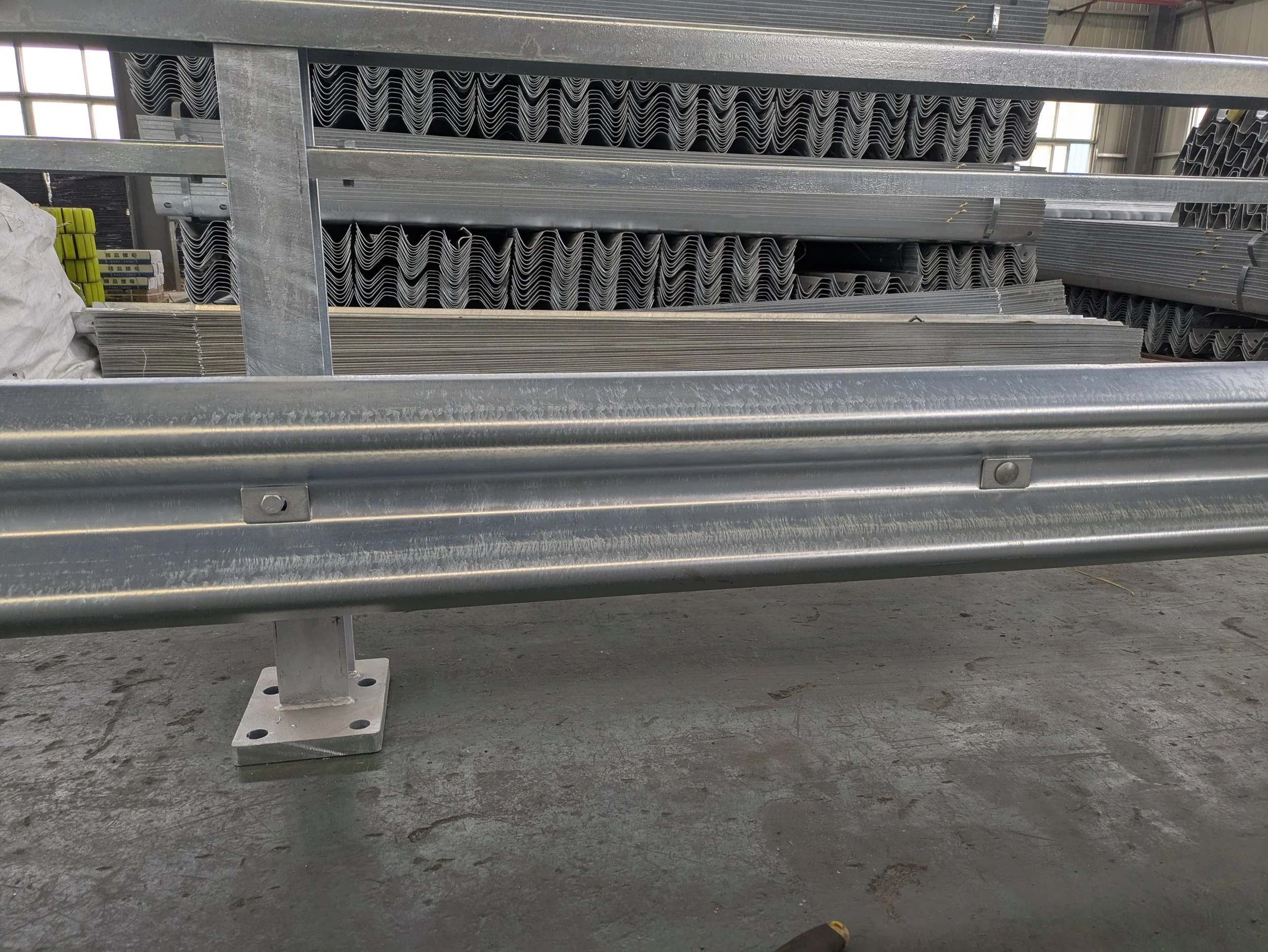 Stacked metal parts and structures in a warehouse or manufacturing setting, including metal rails and other metal components.