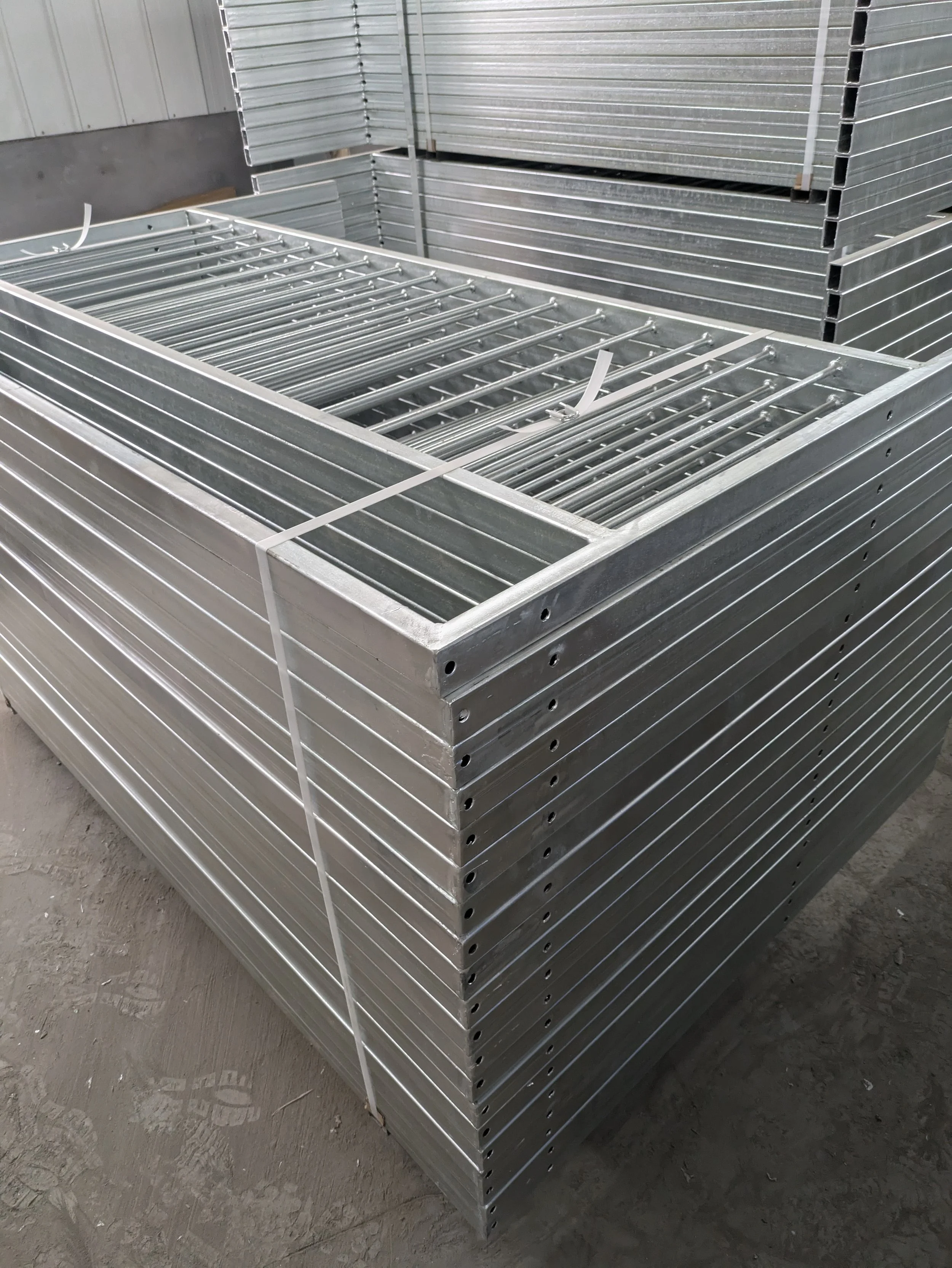 Stacked metal scaffolding frames in a warehouse.