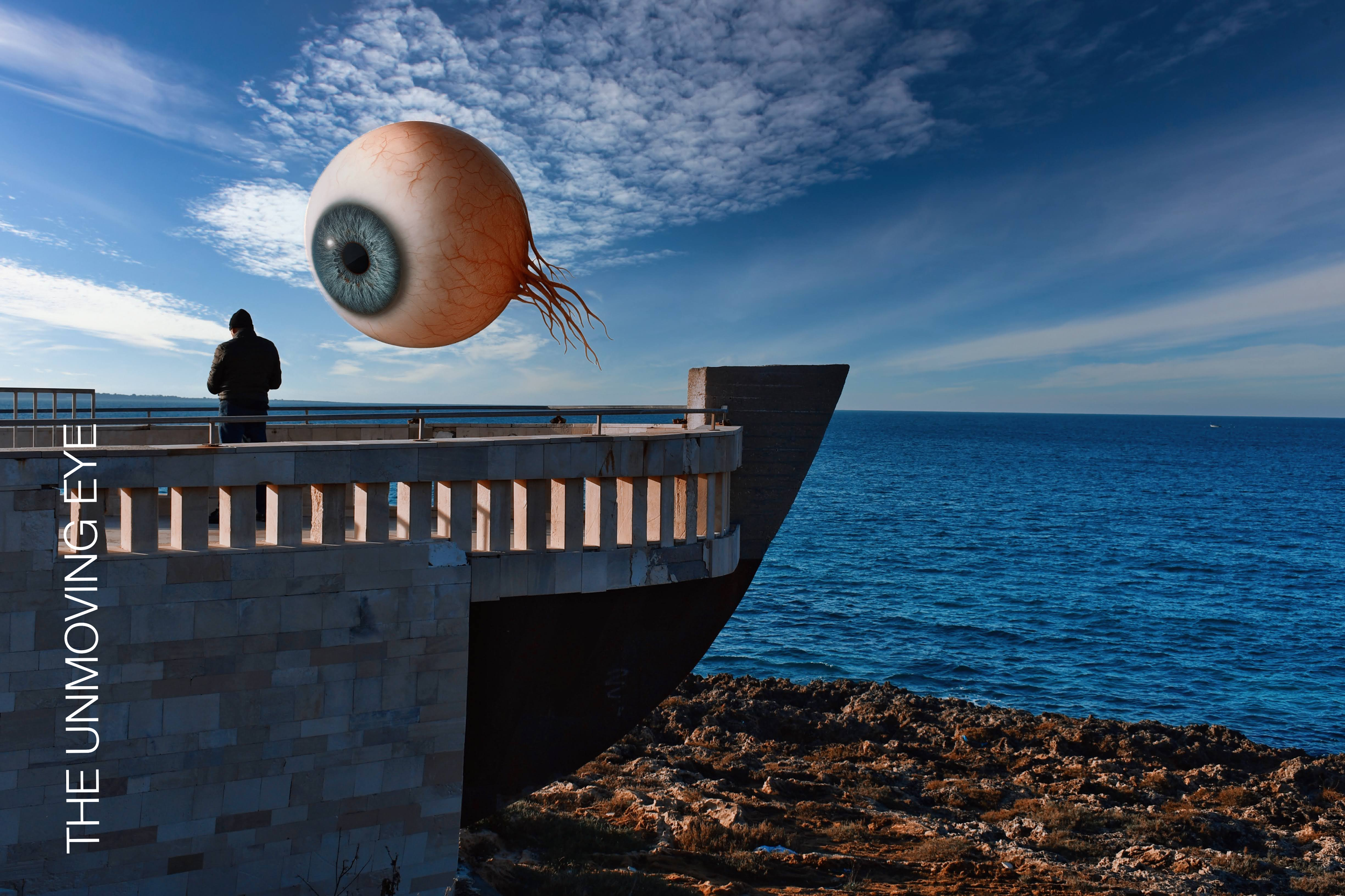 Minimal seascape with surreal floating eye and lone figure on a coastal structure, calm horizon - photograph by Donato Salamanno