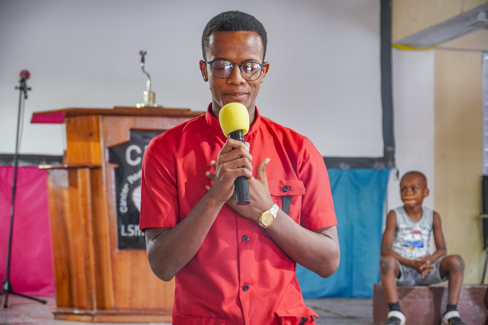 Young man praying into a microphone