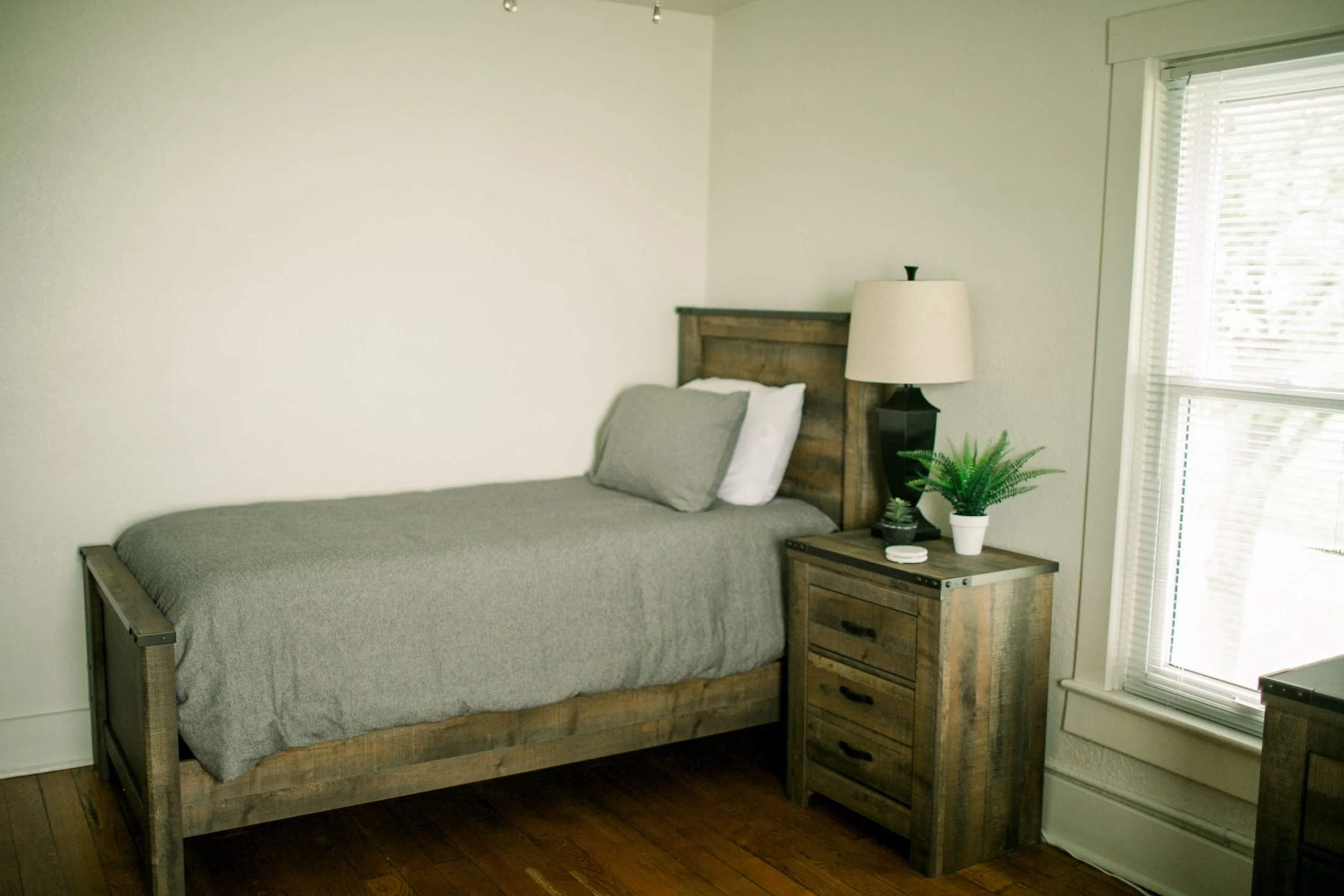 Guest bedroom with a twin bed and lamp. 