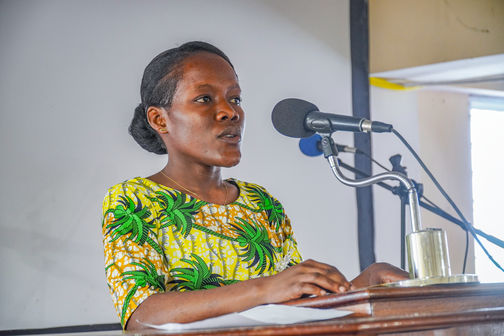 Young Haitian woman speaking confidently into a microphone