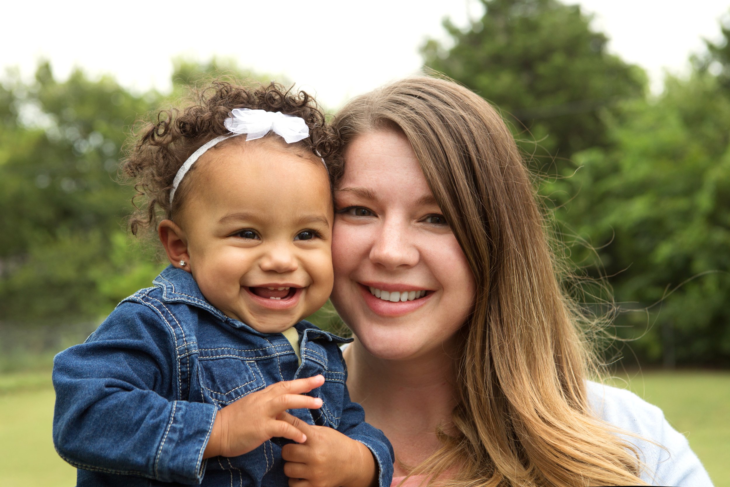 Mother smiling and holding her adopted baby daughter