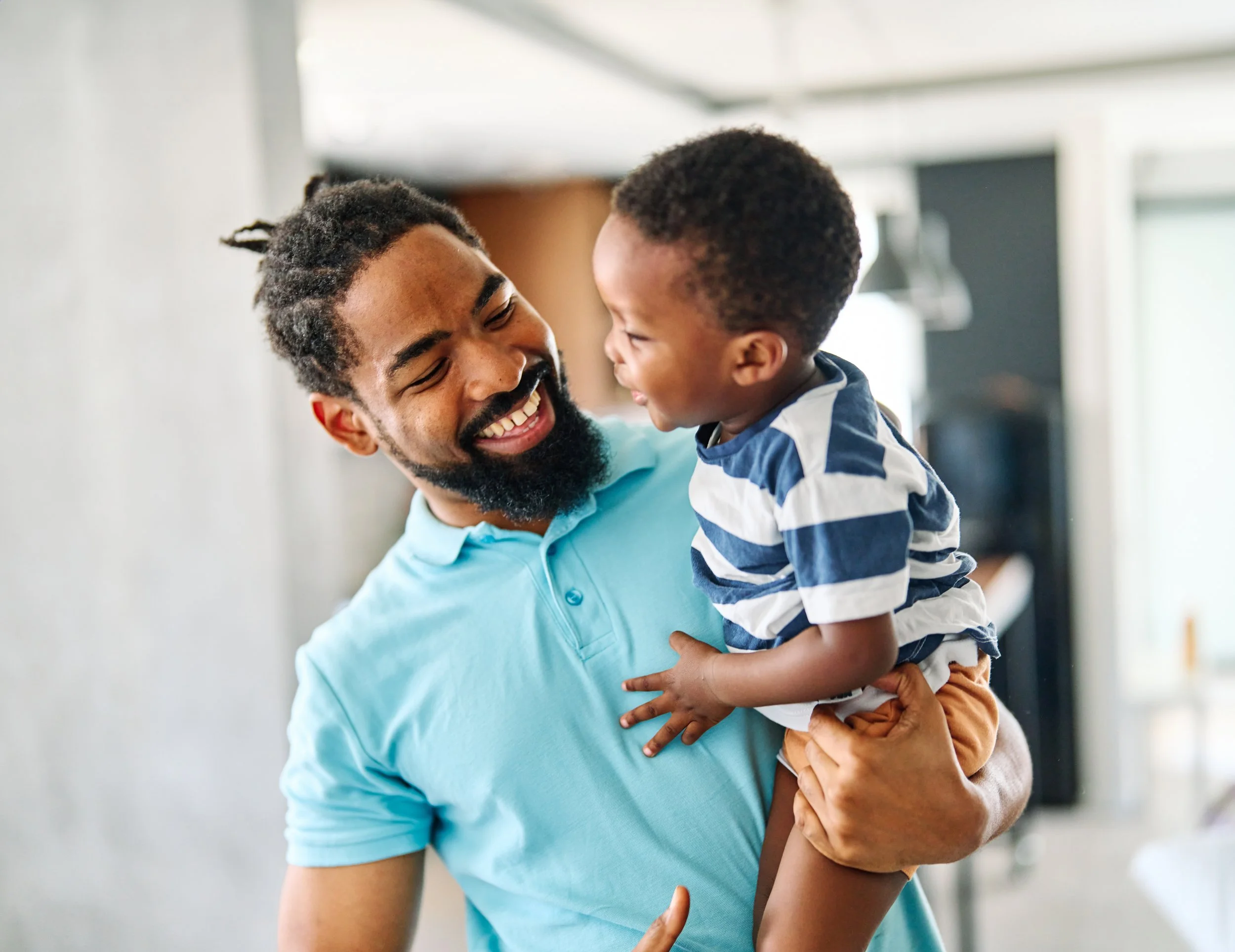 Father laughing and holding his little son