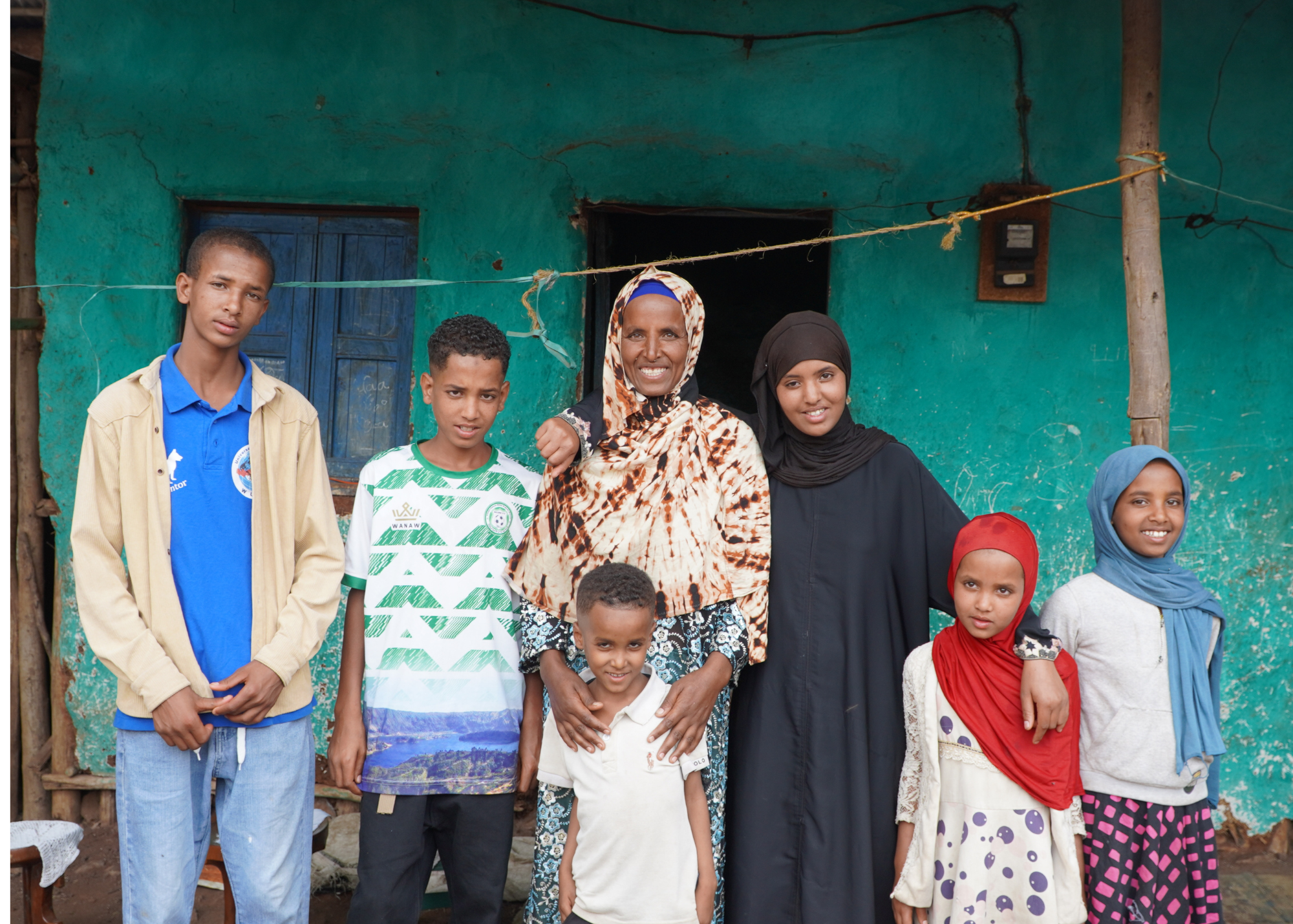 A mother smiling with her large family of three sons and three daughters