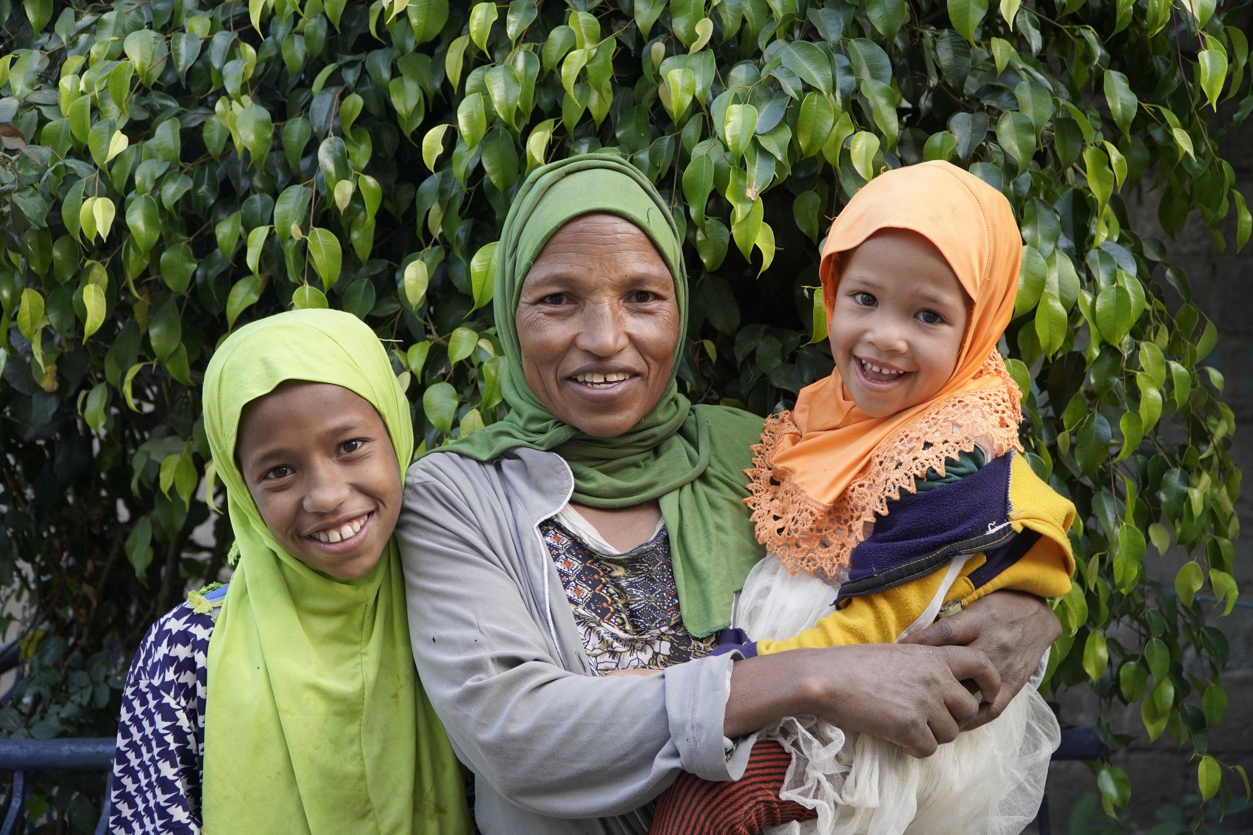 Young Ethiopian mother smiles with her two little daughters