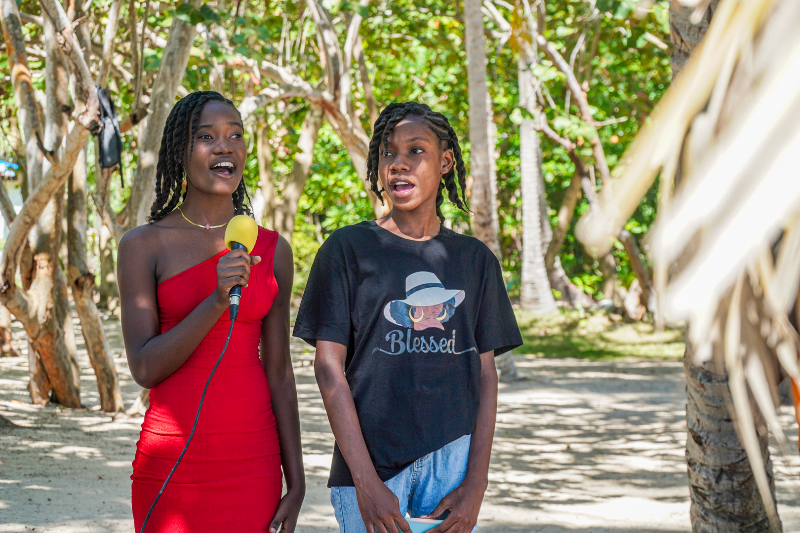 Two young women singing into a microphone