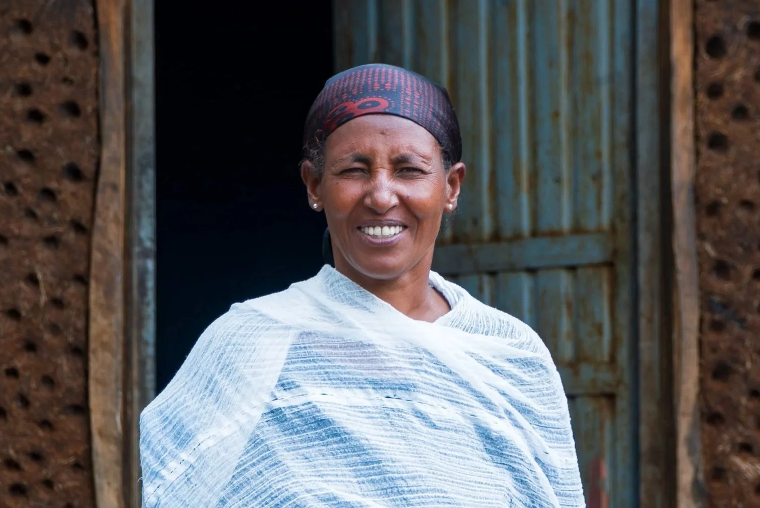 Alem smiling in front of her home