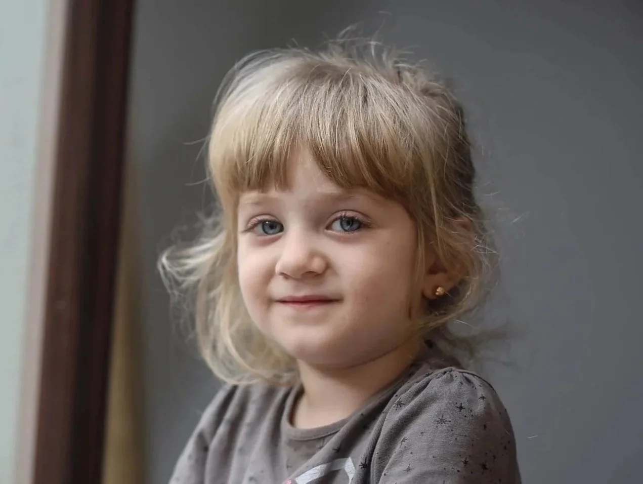 A little Ukrainian girl with blonde hair and blue eyes smiling