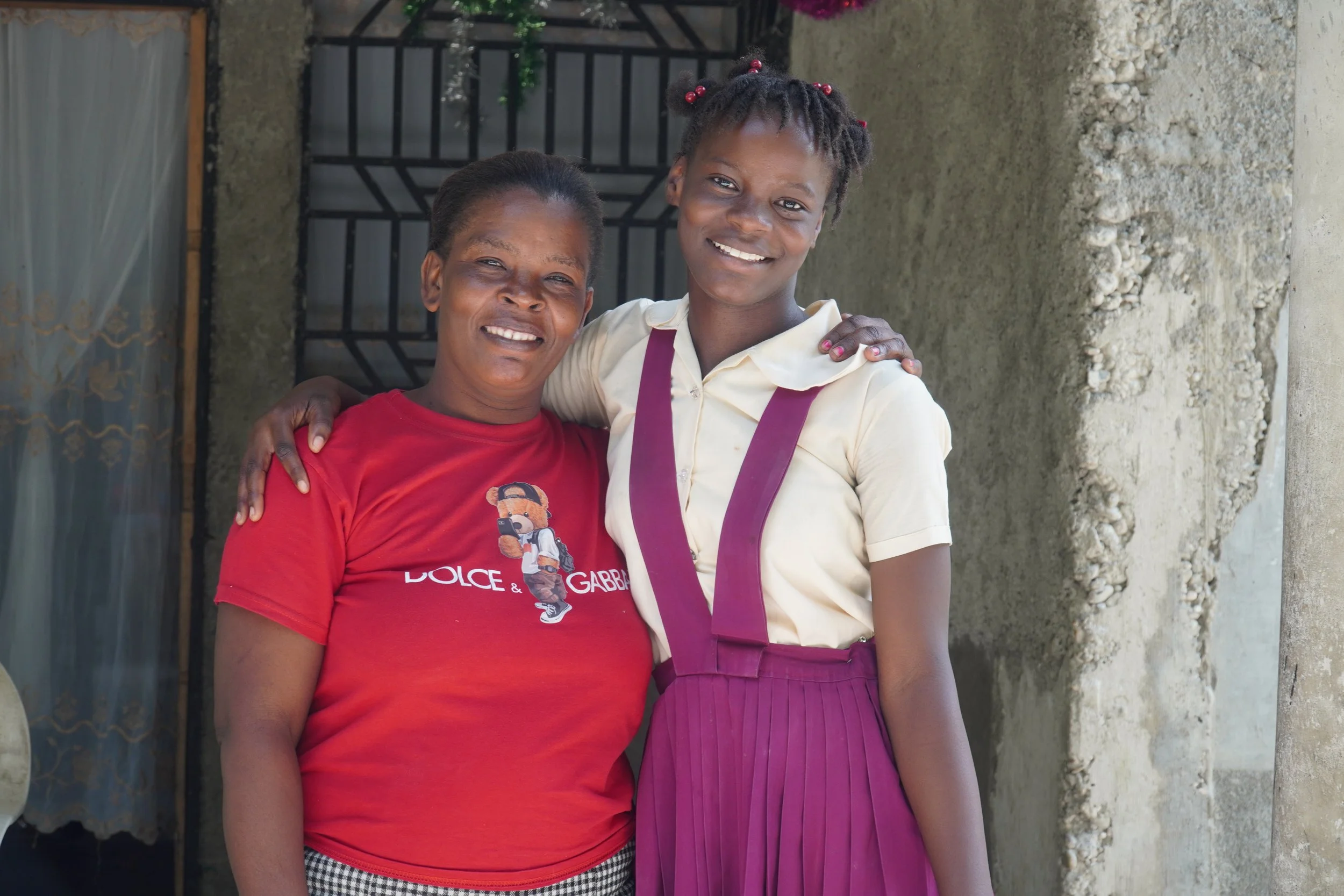 A mother and daughter smile as they hug each other
