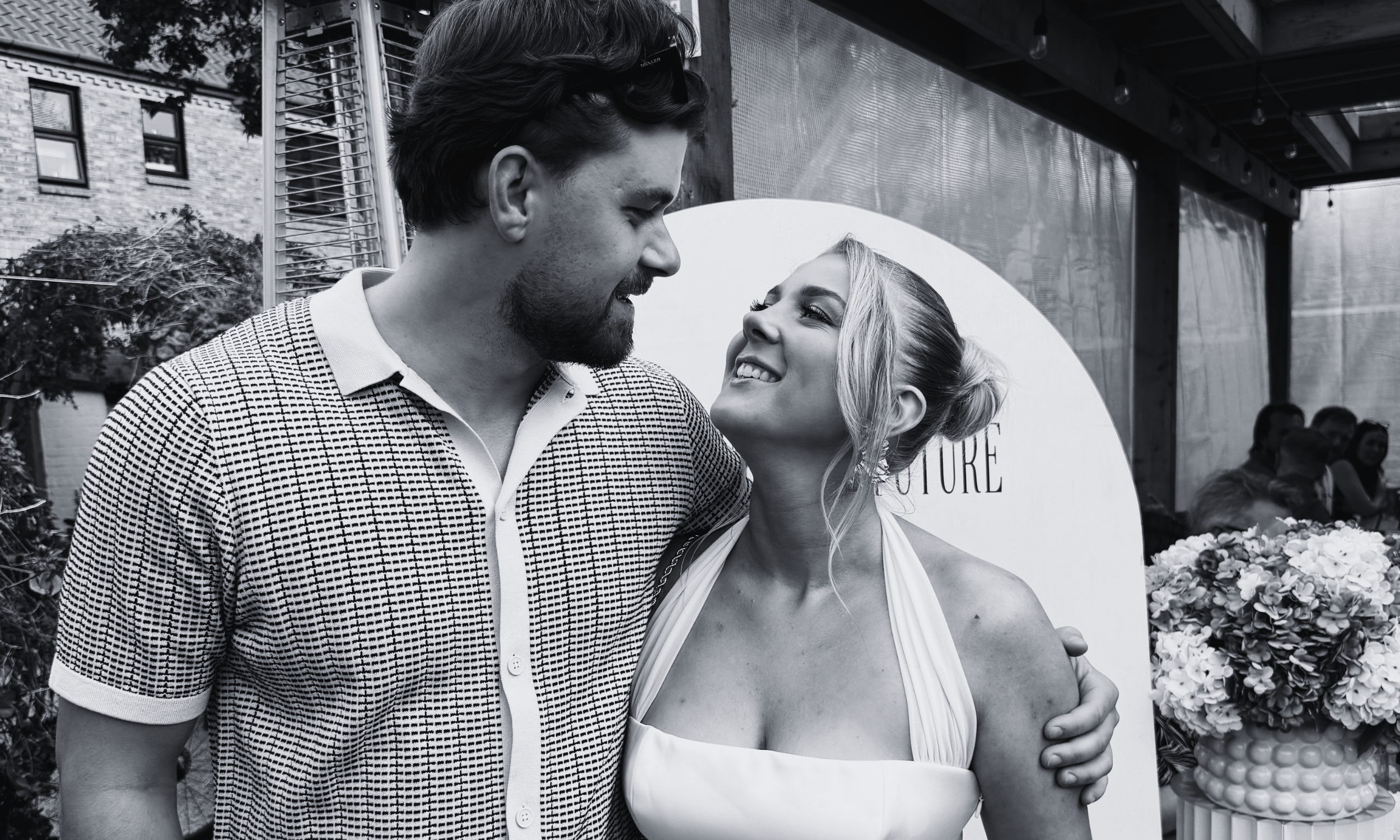 A couple at their engagement party, sharing a loving look.