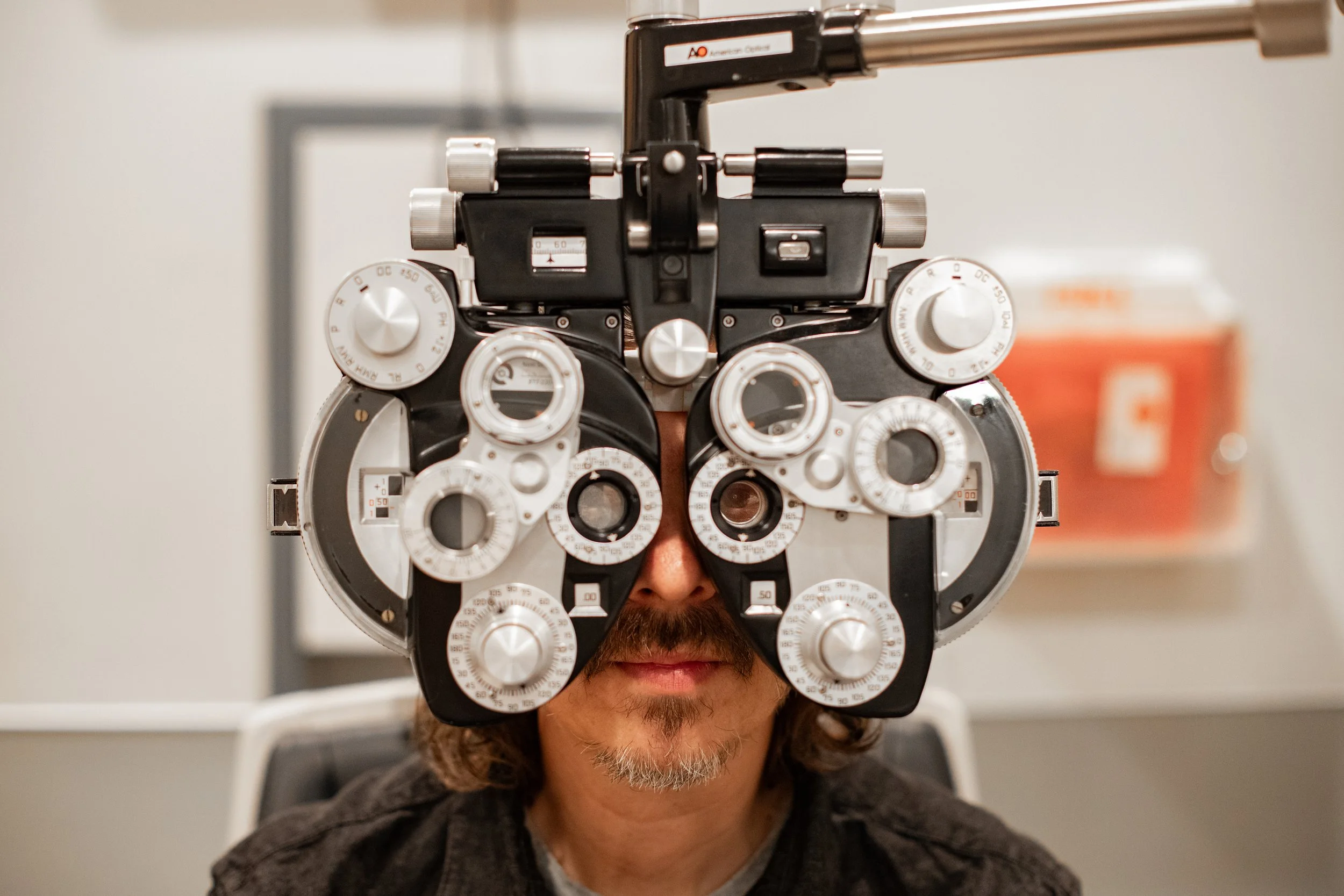 Man looking through a phoropter