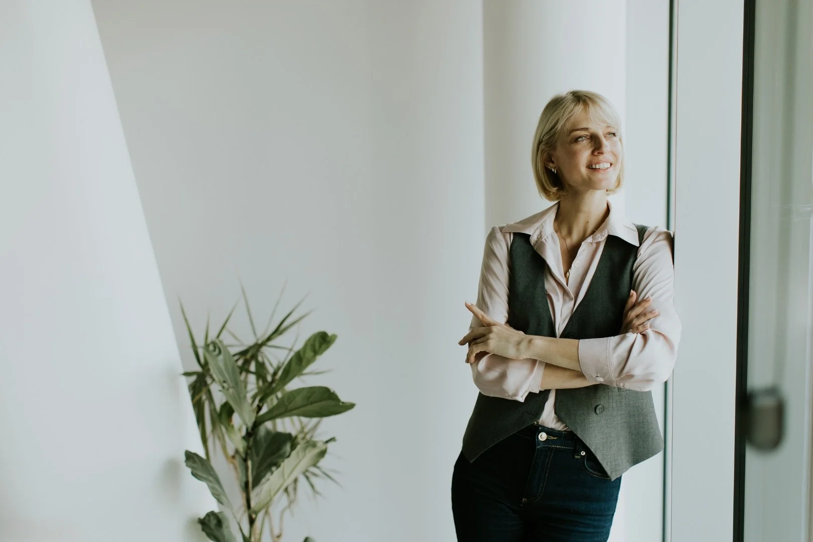 A young woman standing in a room and smiling.