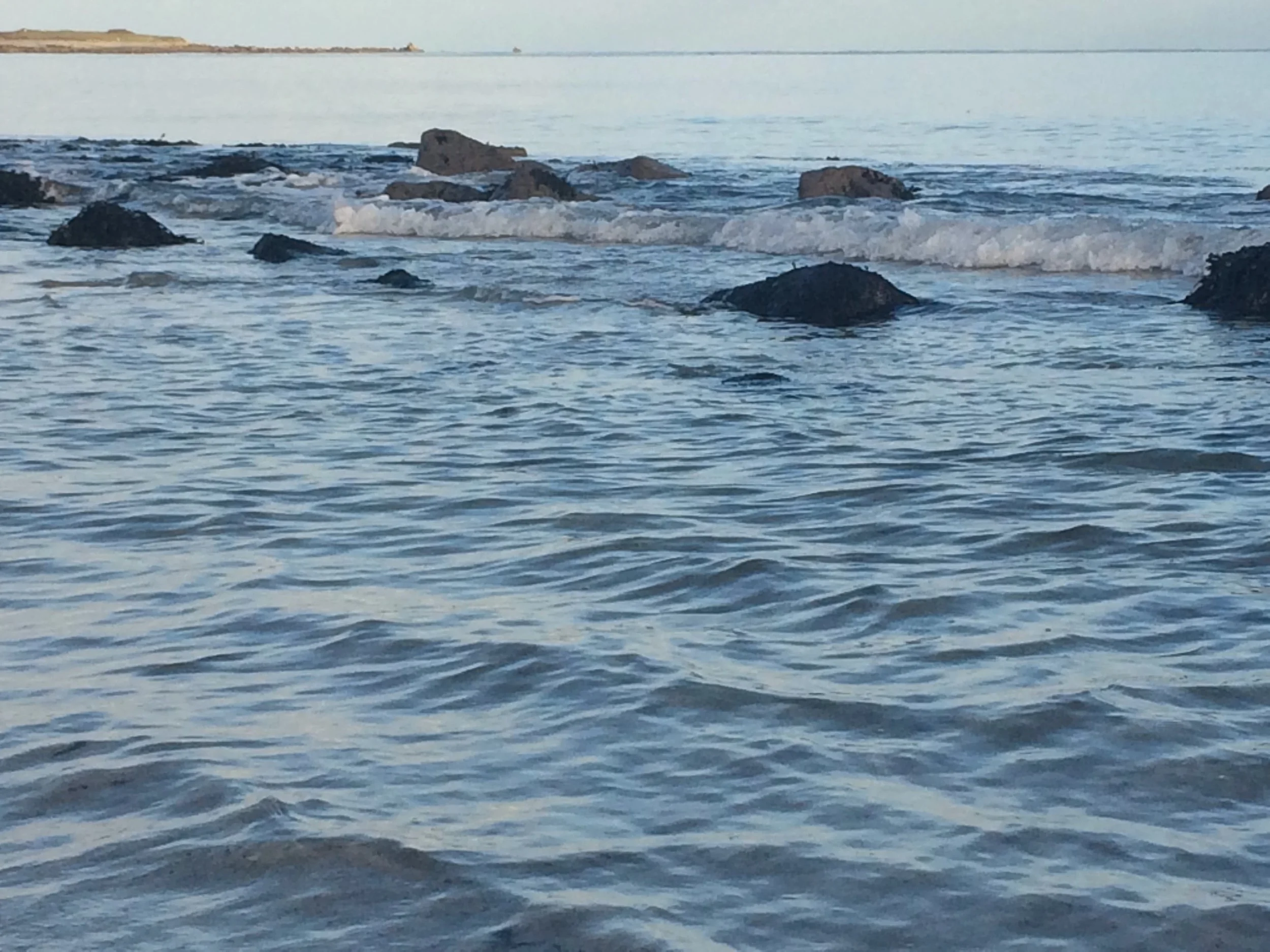 Rocky shoreline with waves crashing on rocks in the ocean