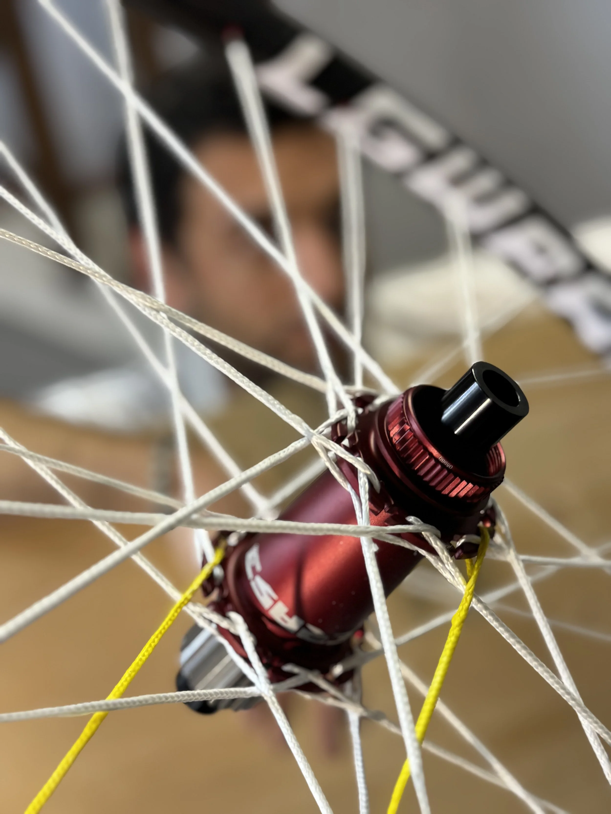 Vista ravvicinata di un mozzo rosso di una ruota di bicicletta intrappolato nel cerchione, con cavi colorati attorno.