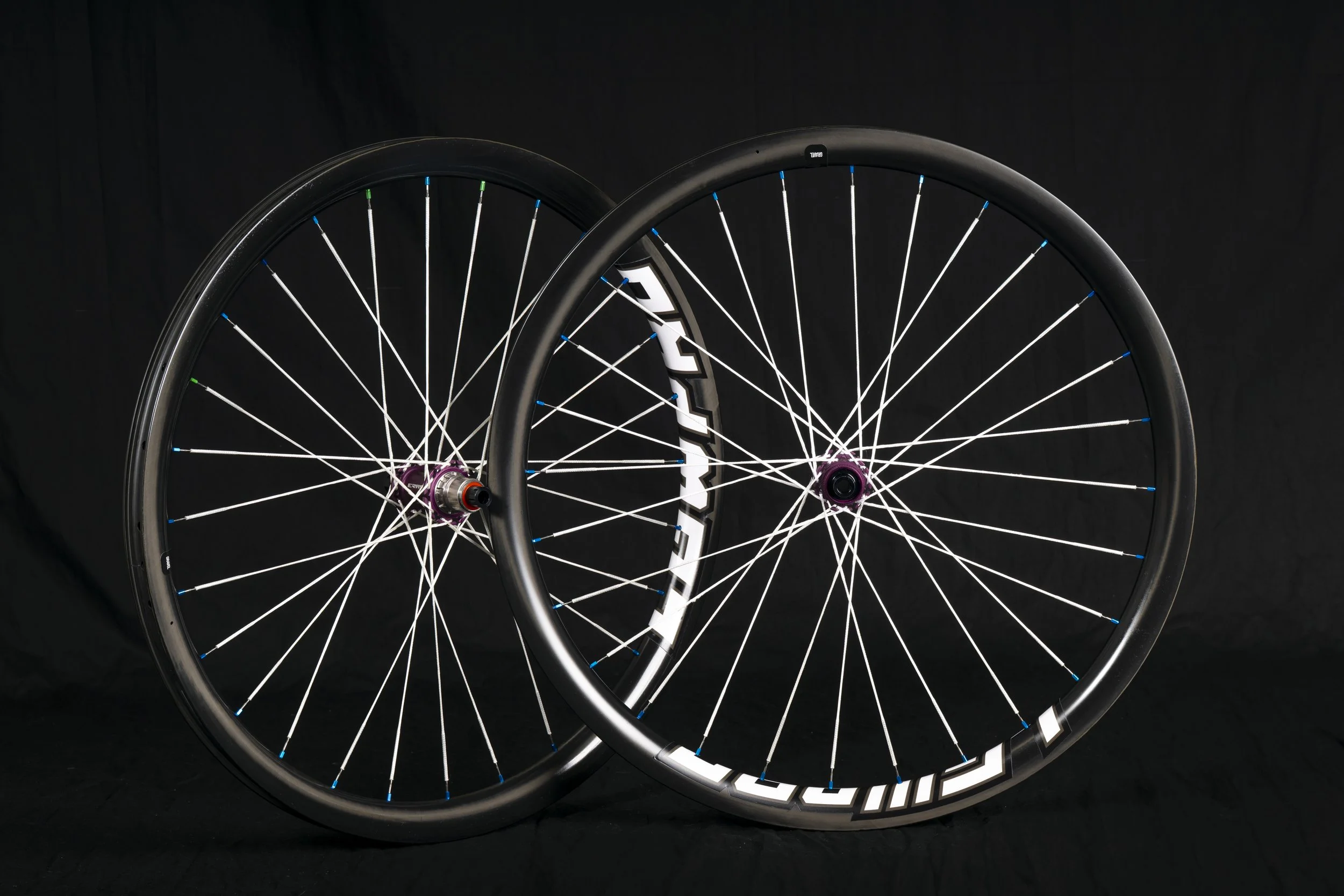 Coppia di ruote in carbonio personalizzate per bicicletta, assemblate a mano nel laboratorio LGWheels. Il montaggio custom include raggi polimerici Berd Spokes e mozzi Erase ad alta scorrevolezza, configurati per ottimizzare il peso e la rigidità.