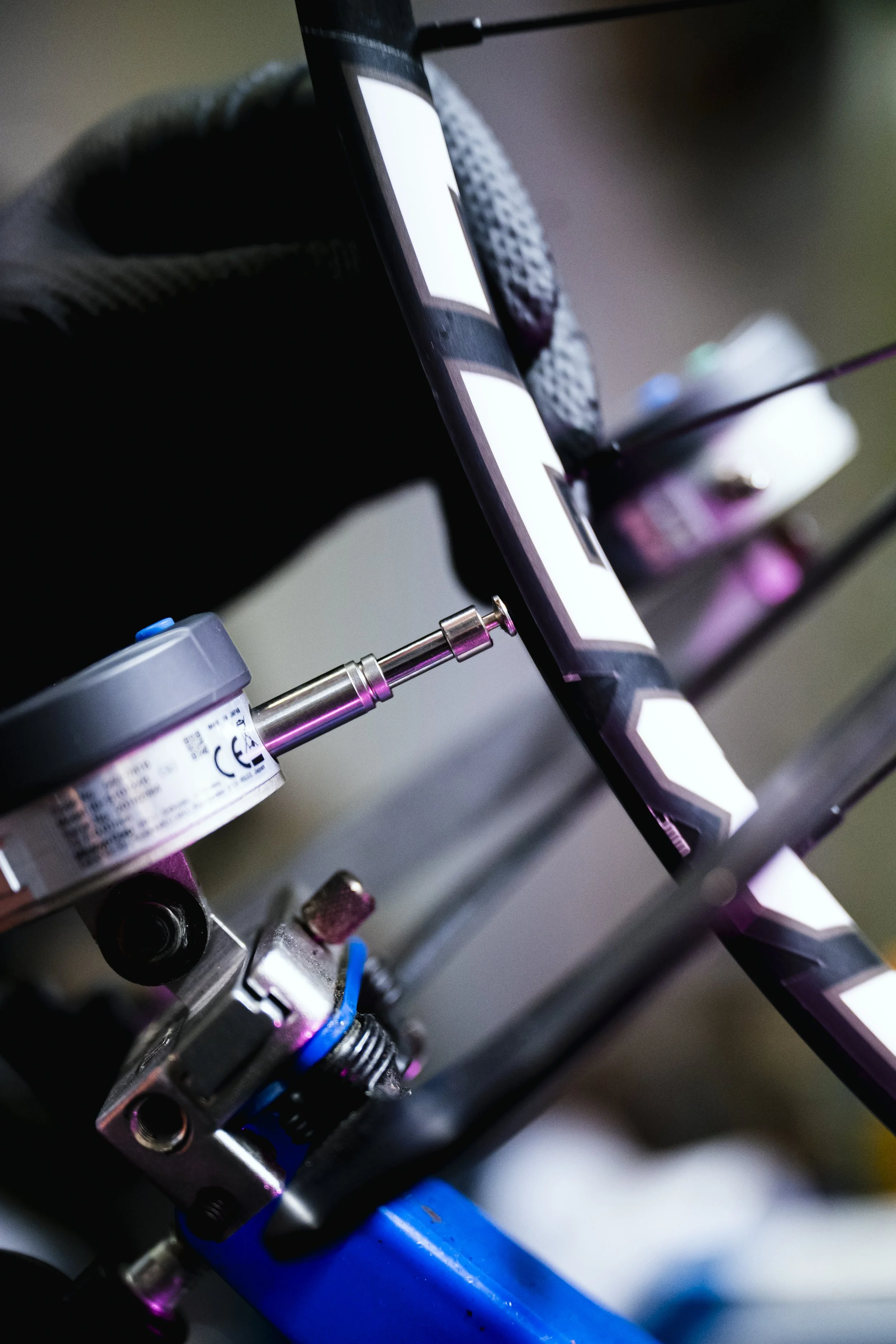 Particolare di un telaio di bicicletta da corsa sotto una luce colorata con strumenti di montaggio.