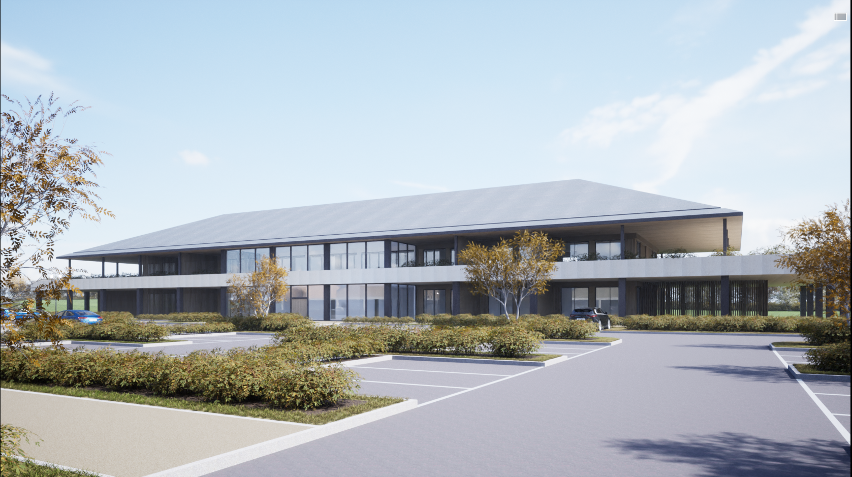 A modern two-story office building with large glass windows, surrounded by a parking lot and landscaped greenery, under a blue sky with some clouds.