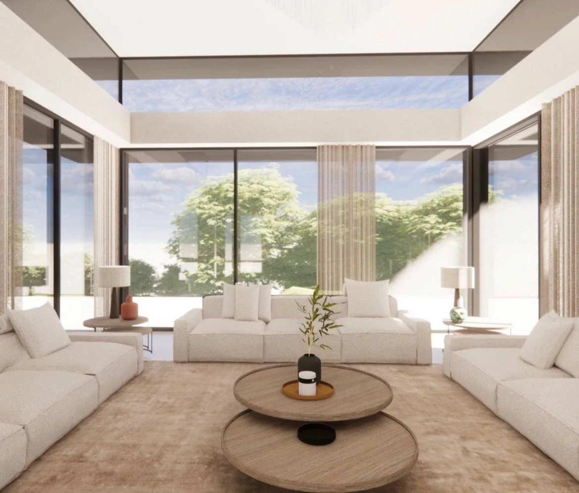 Modern living room with large glass windows, white sofas, and minimal decor, overlooking a garden with trees.