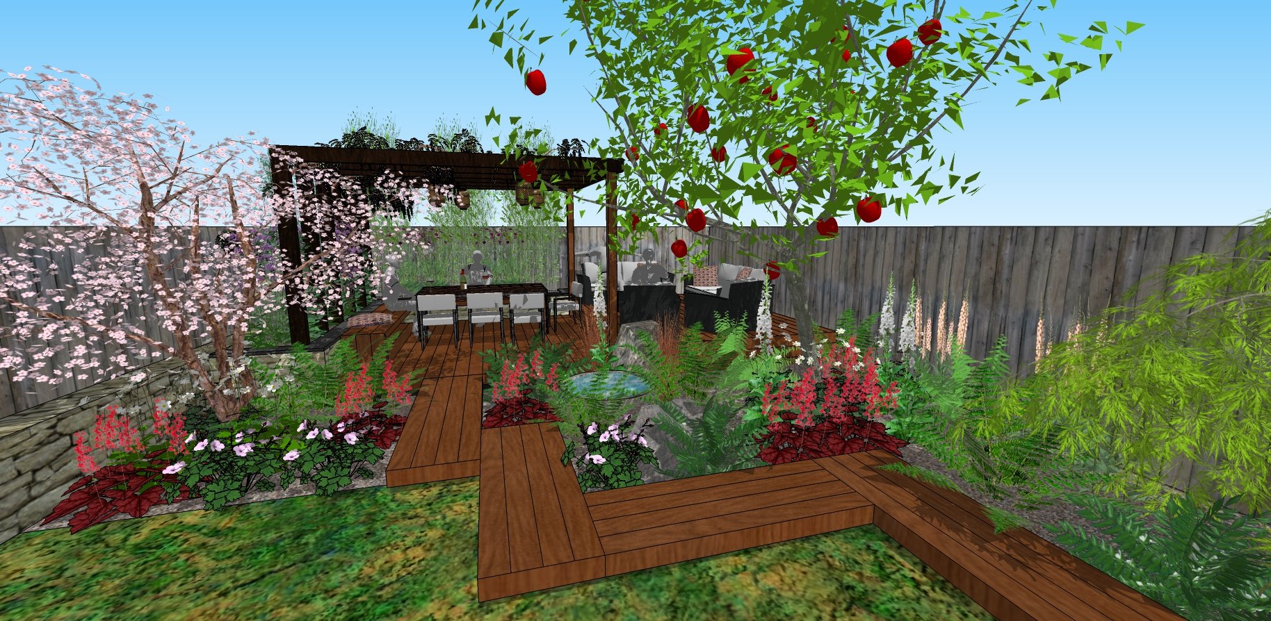 A landscaped backyard garden with a wooden deck featuring a dining table and chairs under a pergola. The garden has blooming cherry blossoms, various colorful flowers, dense green foliage, and a tree with red fruit, all enclosed by a wooden fence.