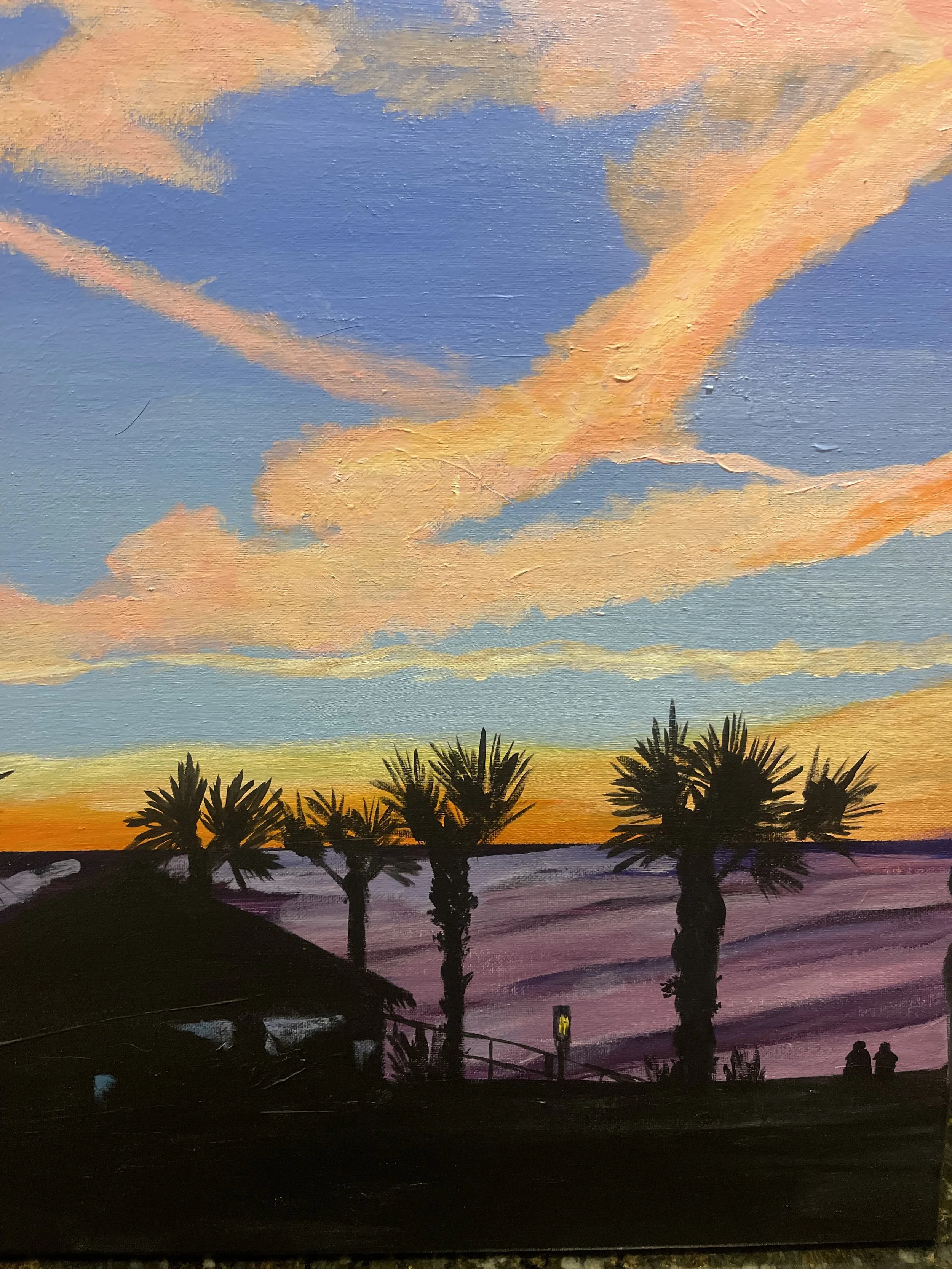 A painted sunset scene with a sky featuring pink, orange, and blue clouds, silhouettes of palm trees, and a dark foreground that includes a small structure and two people sitting.