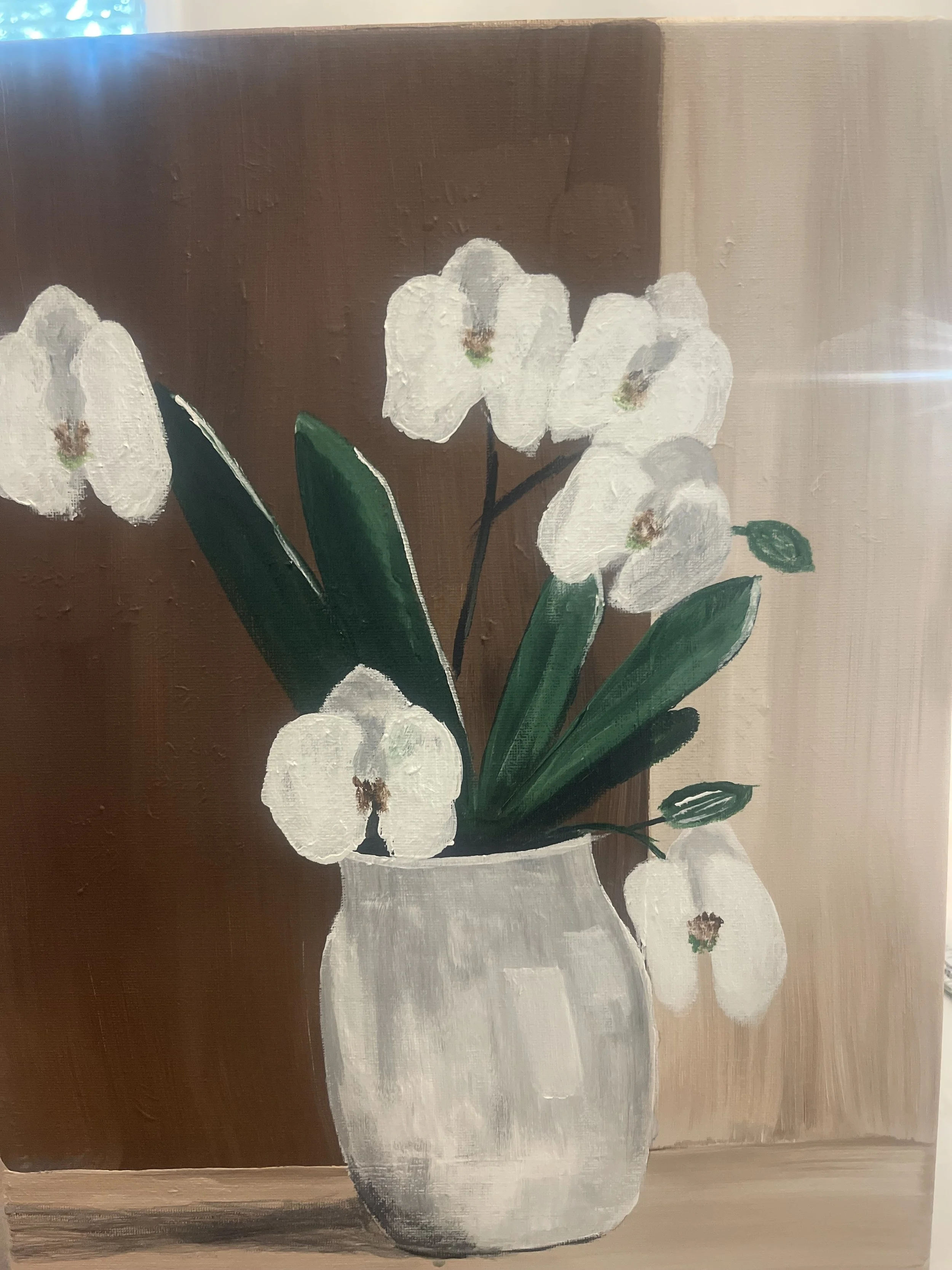Painting of white orchids in a white vase on a wooden surface.