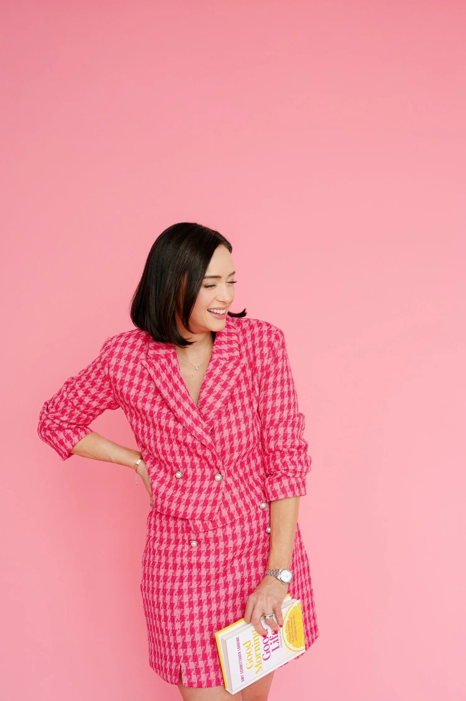 Amy Schmittauer Landino, author of Good Morning, Good Life, holds the book wearing a pink suit.
