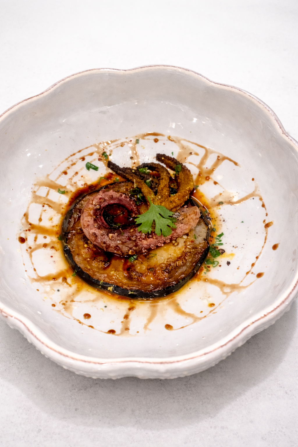 Assiette de légumes grillés avec un filet de sauce et une garniture de coriandre.