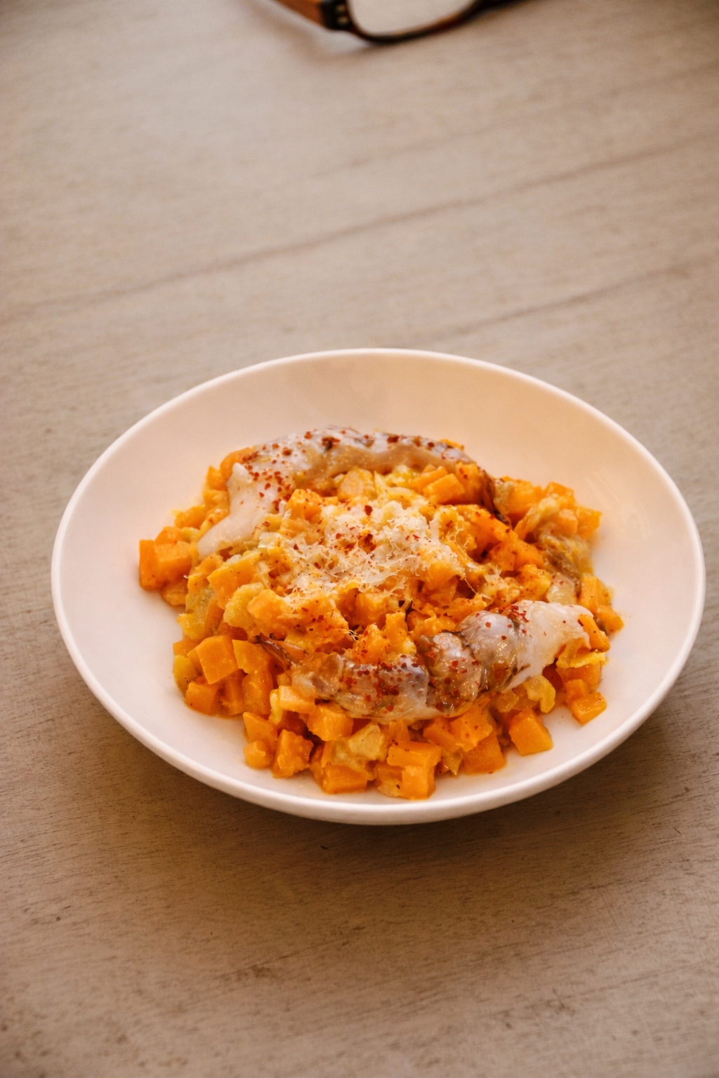 Plat de purée de patate douce avec des morceaux d'œuf dur, de la sauce et une pincée de paprika sur le dessus.