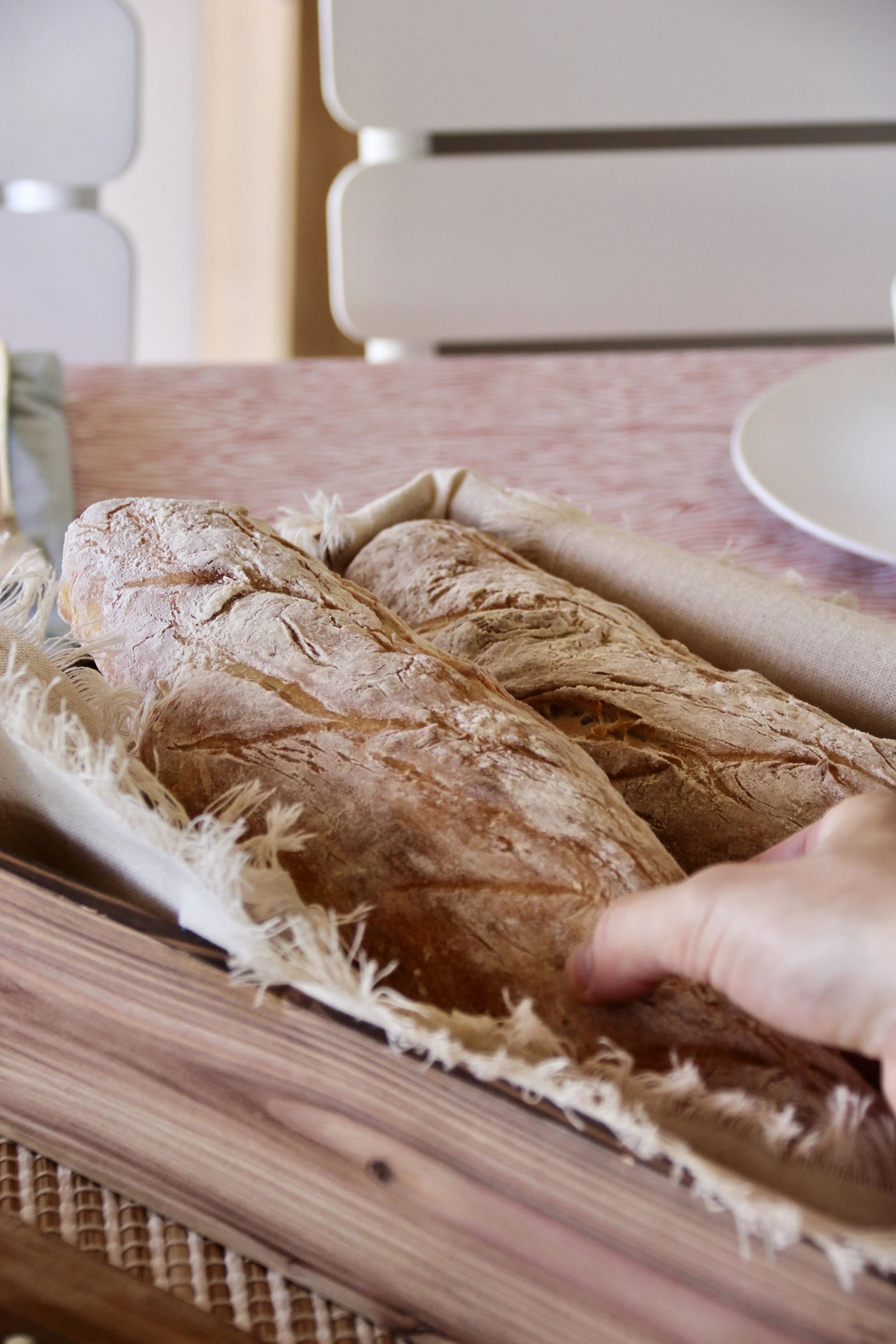 Deux baguettes de pain sur une table en bois, avec un fond flou.