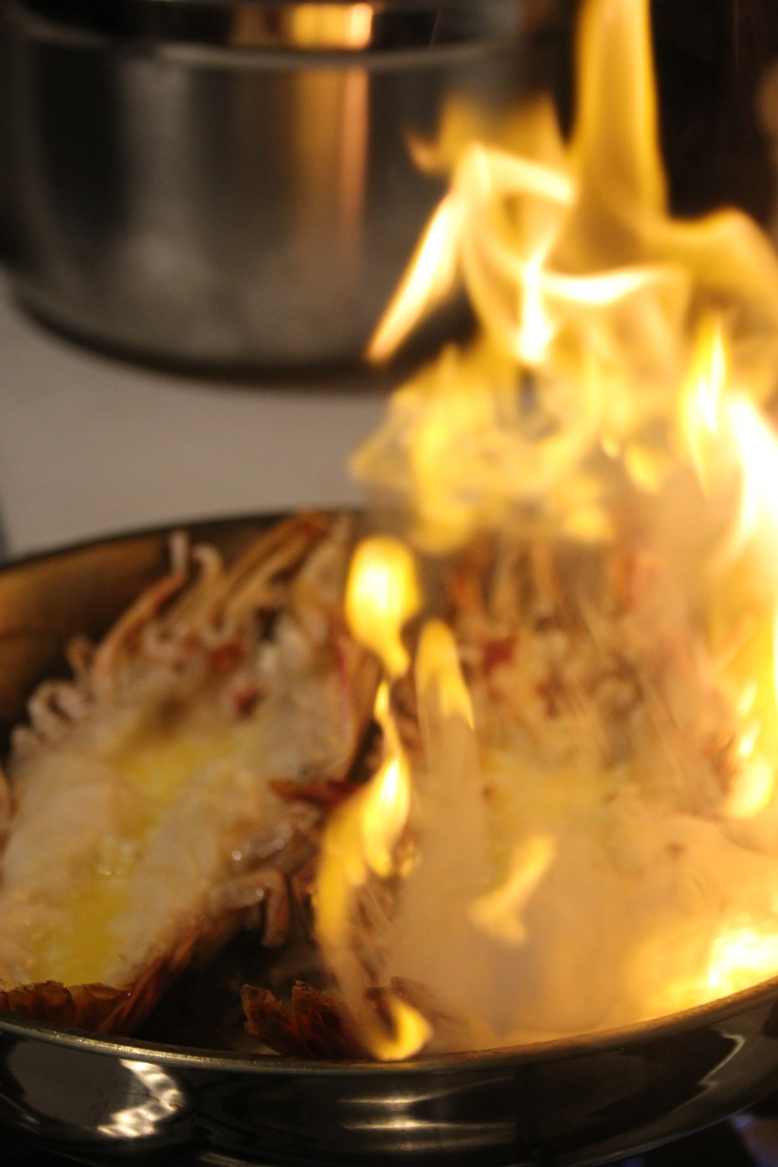 Poisson en train de brûler sous une flamme dans une poêle, cuisine en cours.
