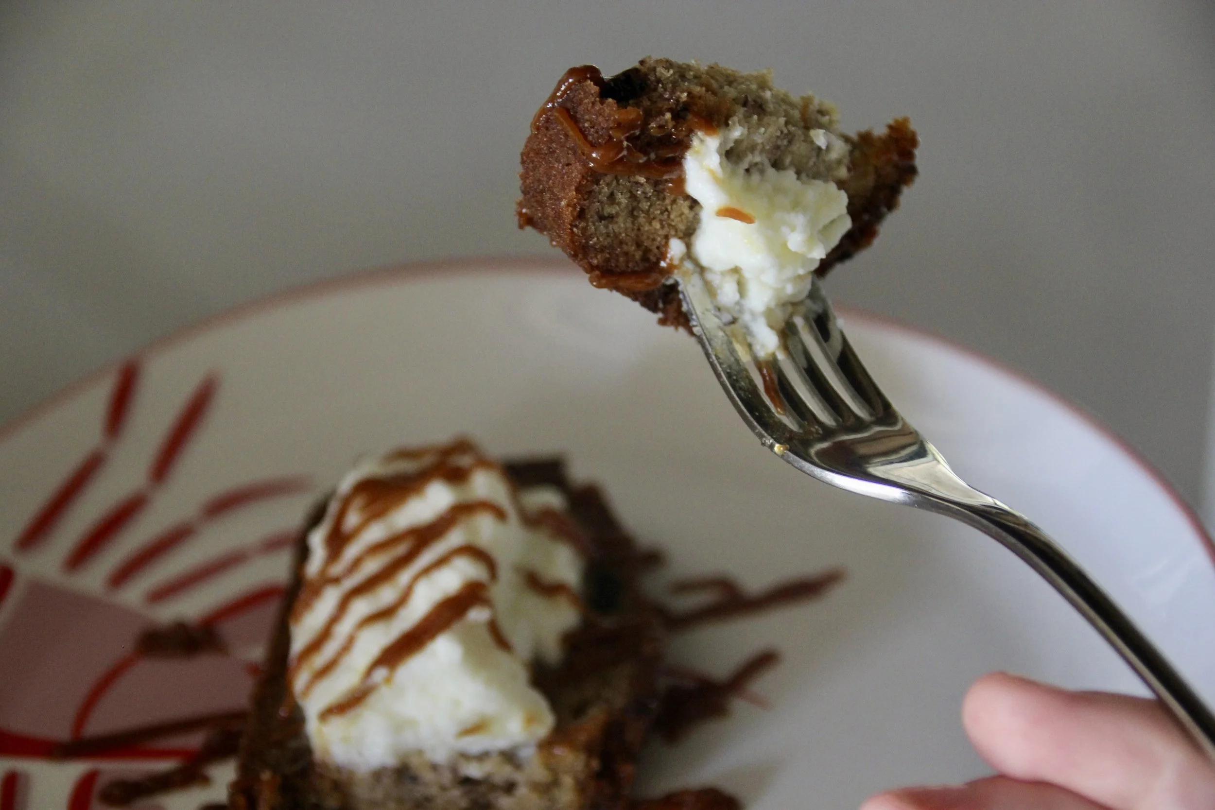 Partie de gâteau au chocolat avec de la crème fouettée, servi dans une assiette blanche avec des décorations en chocolat.