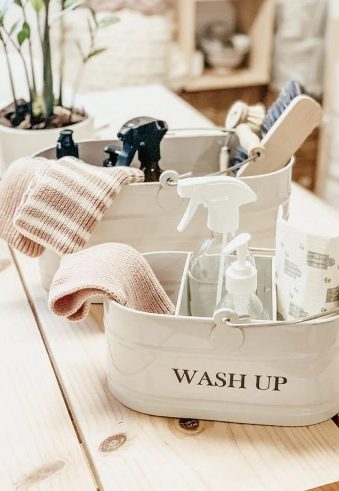 Cleaning caddy with spray bottle, towels, brushes, and spray bottles, labeled 'Wash Up'.