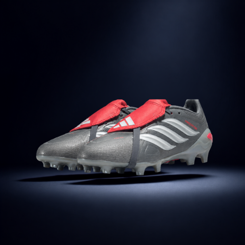 Pair of gray and black soccer cleats with red accents and white stripes on a dark background.