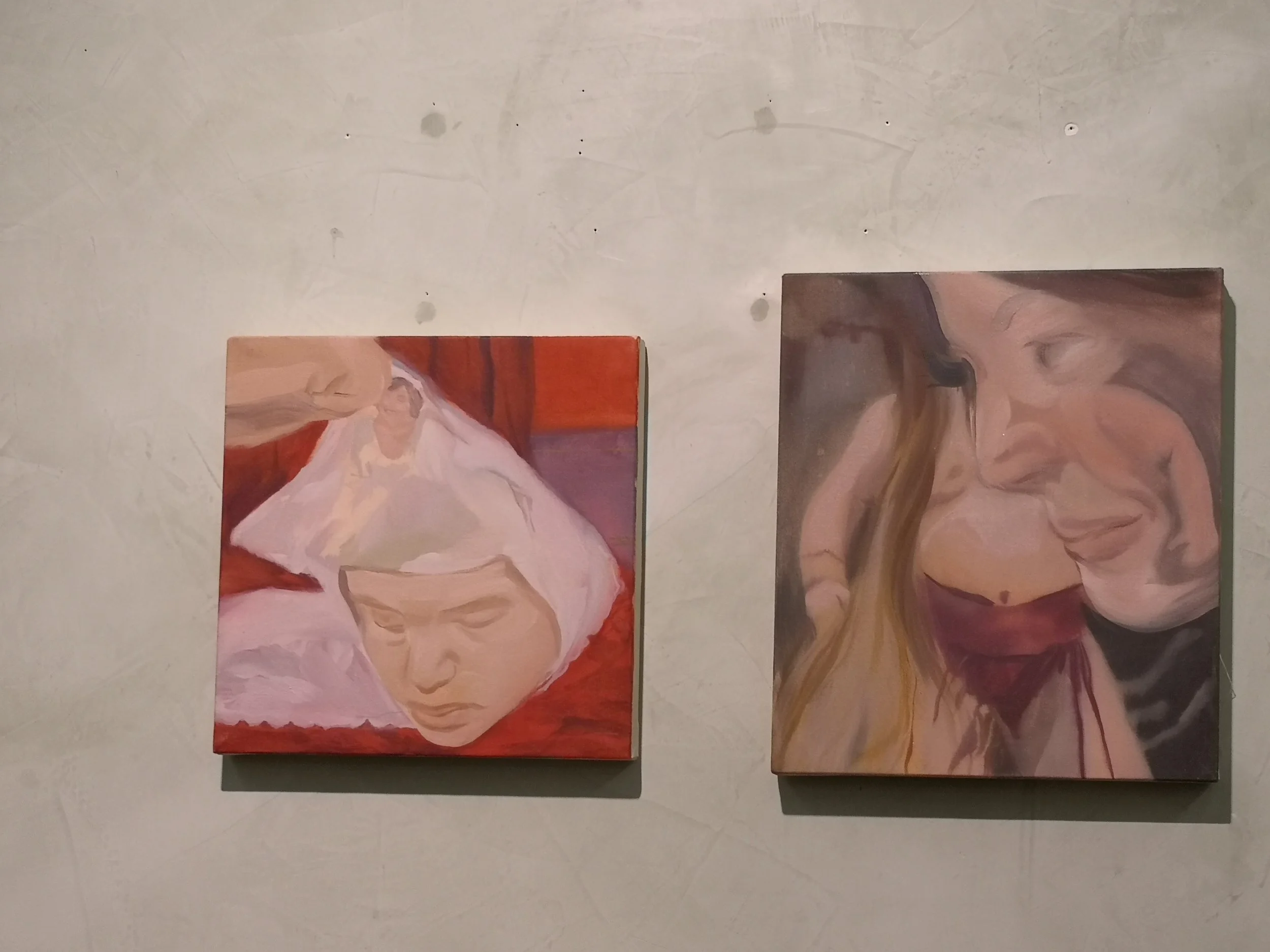 Due dipinti di ritratti di donne appesi a una parete tuscan. La prima donna ha i capelli bianchi e capelli lunghi, con occhi chiusi. La seconda donna ha i capelli lunghi castani e ha gli occhi chiusi, sorridendo.