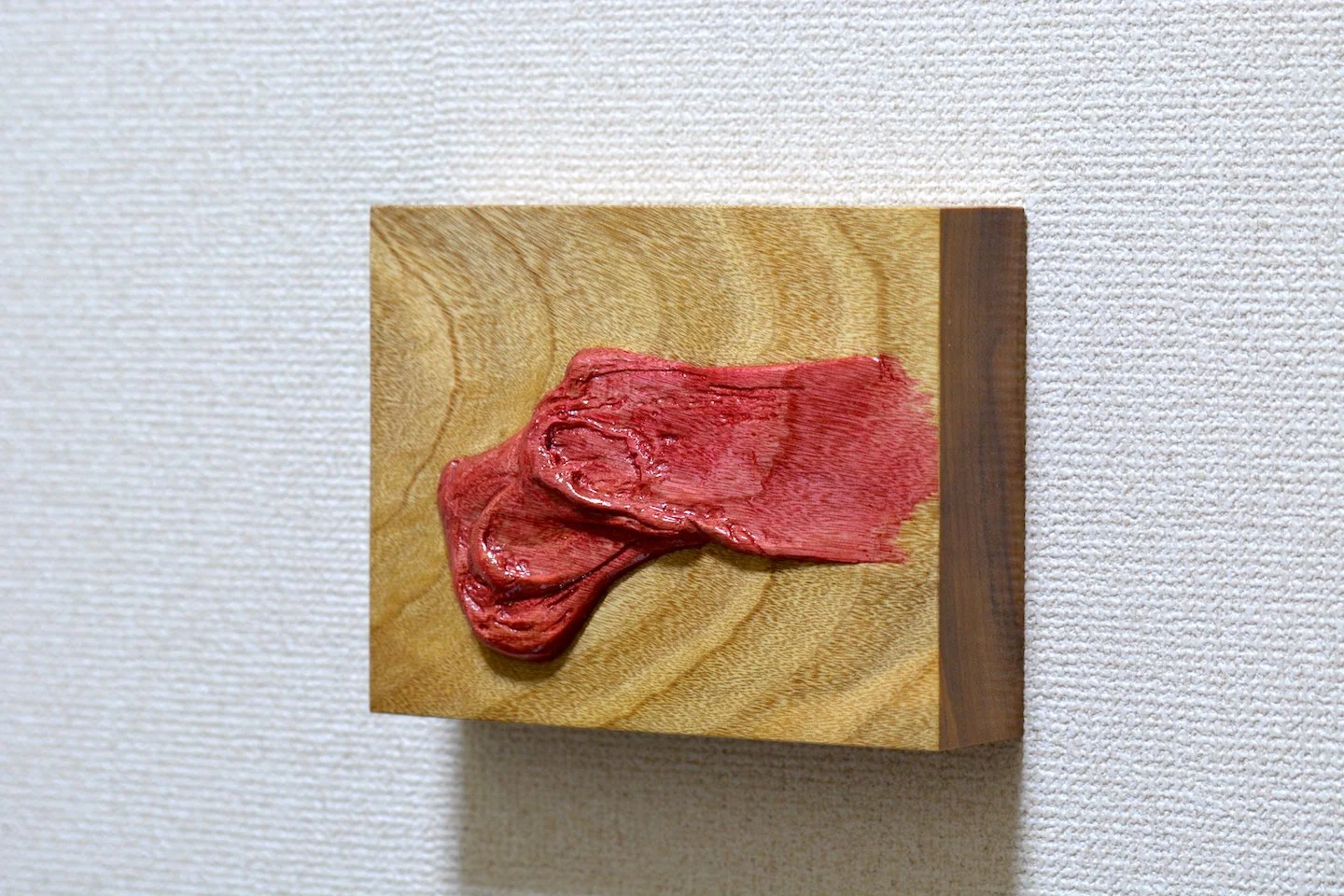 Statua di carne umana dall'aspetto artistico su una piastra di legno.
