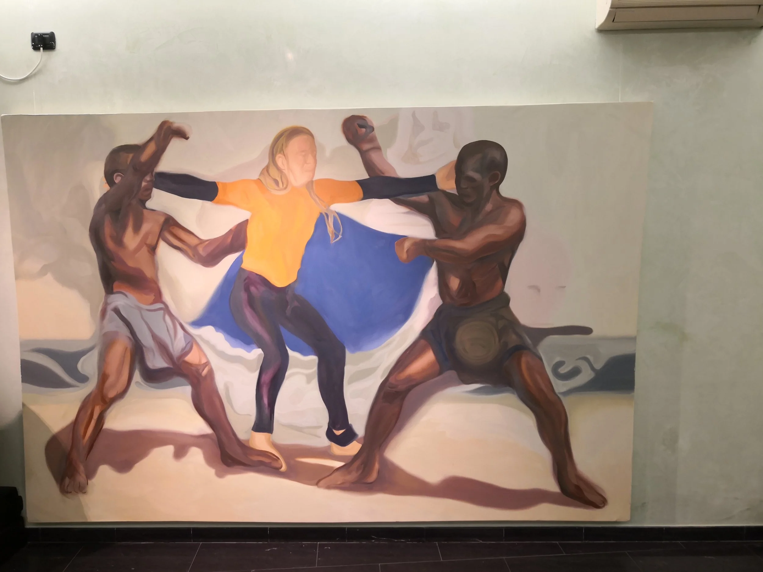 Dipinto che raffigura quattro persone mentre praticano la lotta, con una donna al centro che tiene in braccio due uomini, uno su ciascun lato.