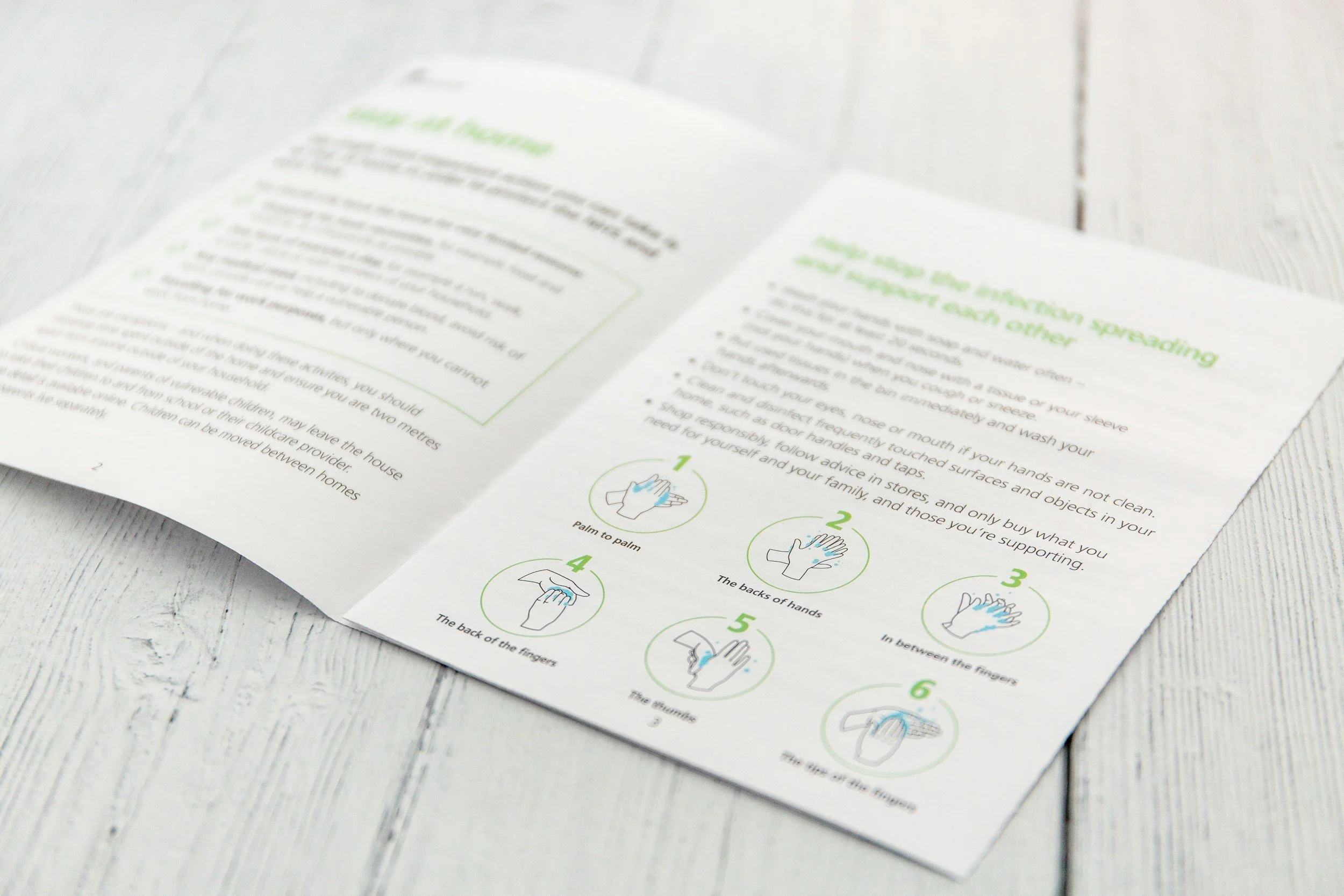 Instruction sheet on hand washing and infection control placed on a white wooden surface.