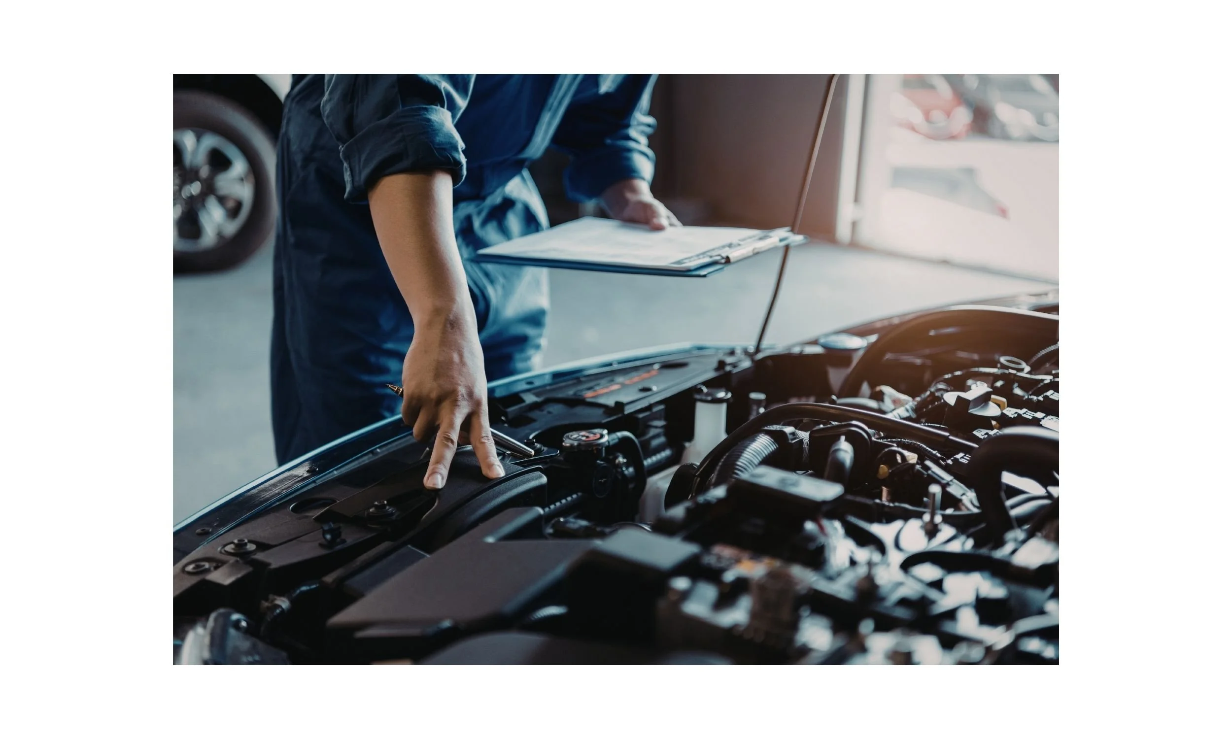 A mechanic checking a car engine with a clipboard in a garage